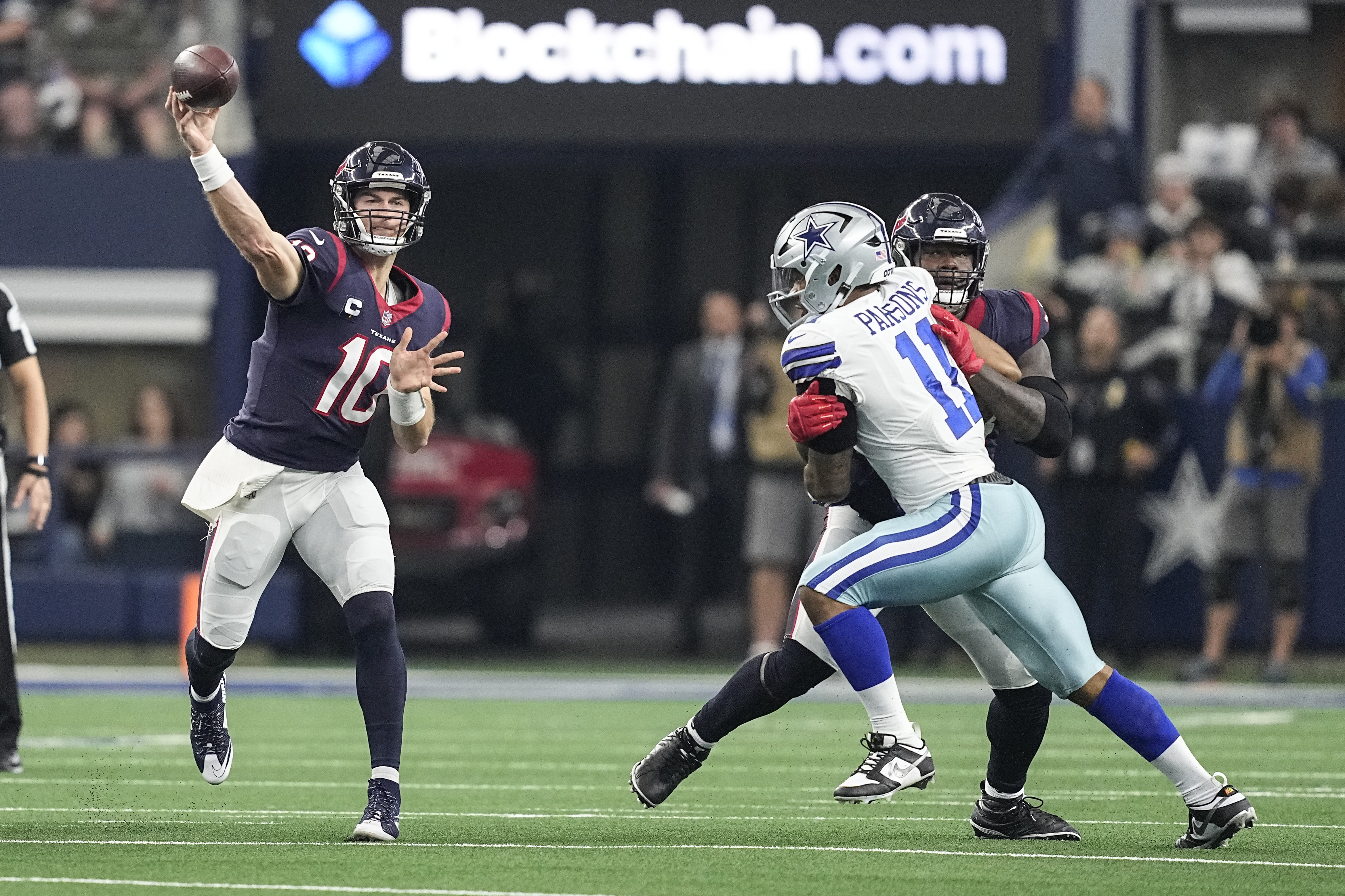 Houston Texans quarterback Davis Mills (10) throws a pass under pressure from Dallas Cowboys linebacker Micah Parsons (11) during the first half of an NFL football game, Sunday, Dec. 11, 2022, in Arlington, Texas. 
