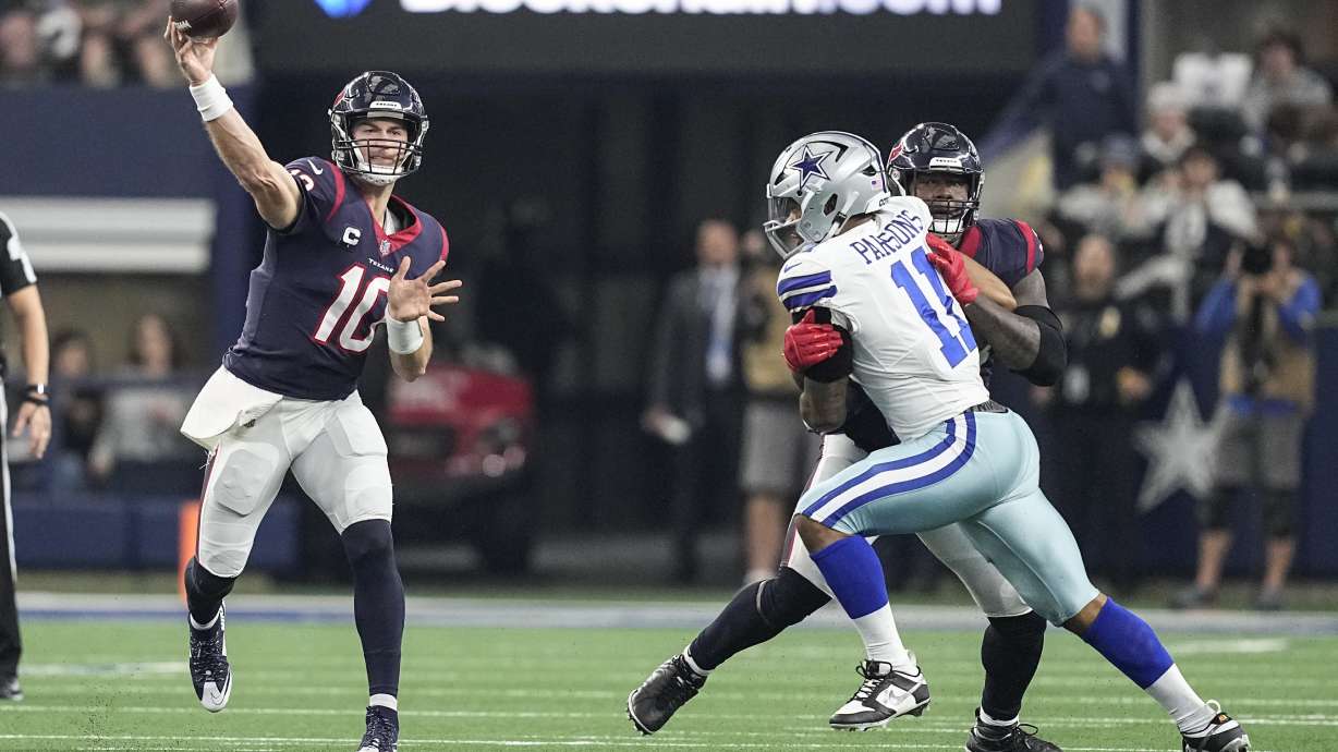 Houston Texans quarterback Davis Mills (10) throws a pass under pressure from Dallas Cowboys linebacker Micah Parsons (11) during the first half of an NFL football game, Sunday, Dec. 11, 2022, in Arlington, Texas.