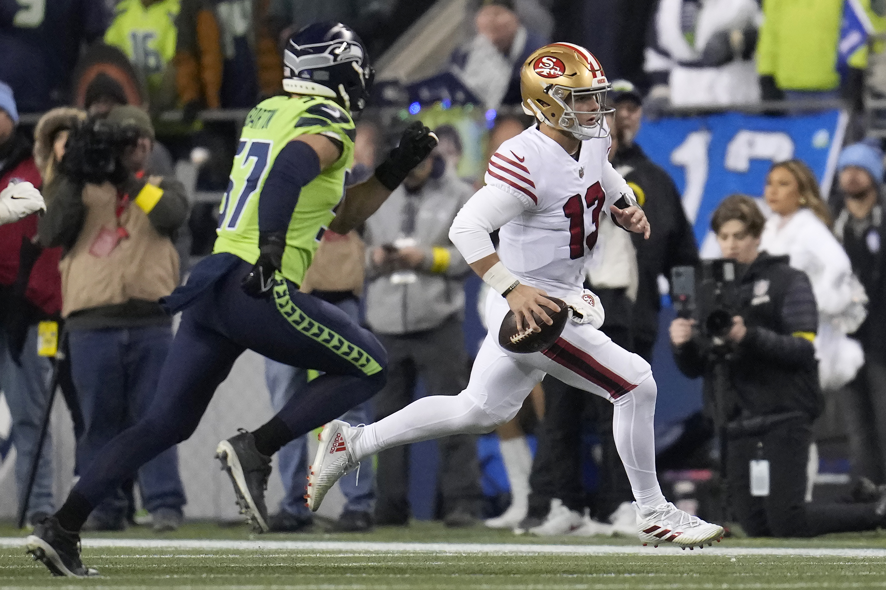 San Francisco 49ers quarterback Brock Purdy (13) runs against Seattle Seahawks linebacker Cody Barton (57) during the first half of an NFL football game in Seattle, Thursday, Dec. 15, 2022.