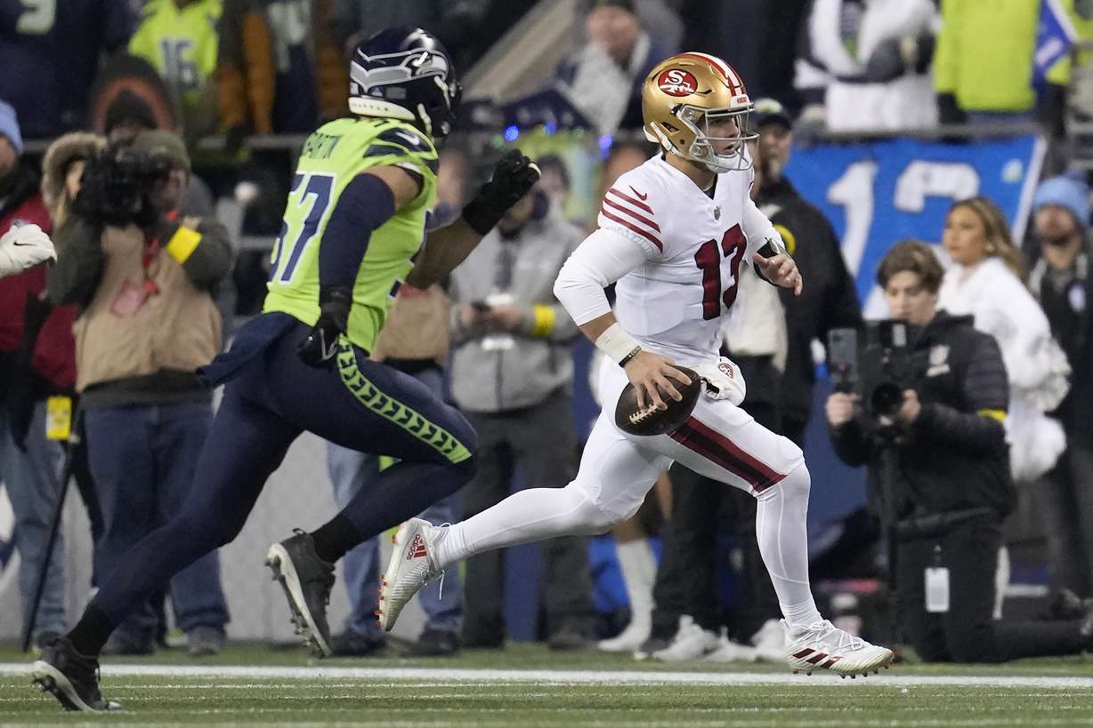 San Francisco 49ers quarterback Brock Purdy (13) runs against Seattle Seahawks linebacker Cody Barton (57) during the first half of an NFL football game in Seattle, Thursday, Dec. 15, 2022.