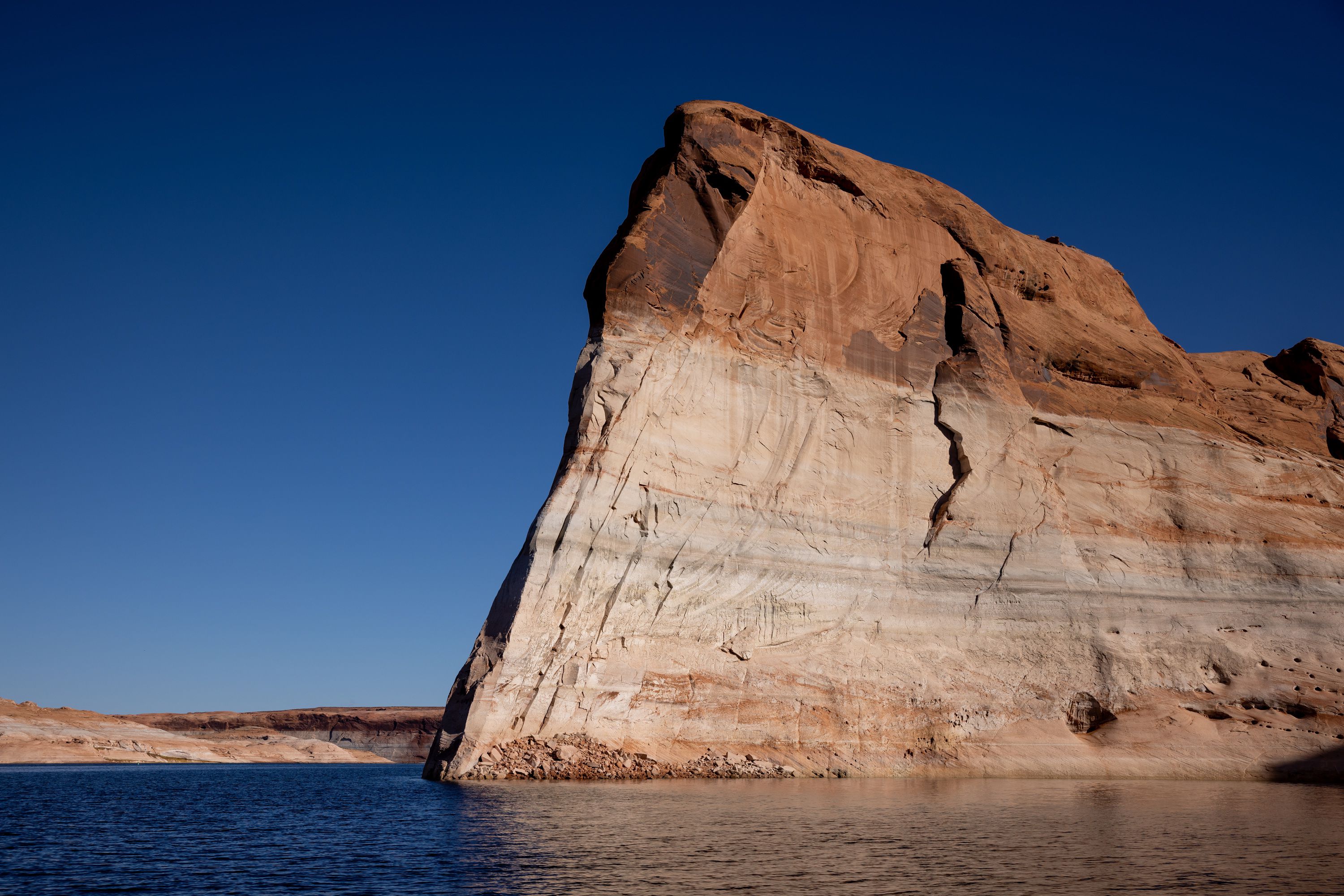 Lake Powell’s “bathtub ring,” a light-colored coating of mineral deposits left during periods of higher water on the reservoir, is seen on canyon walls on Oct. 6 near Bullfrog. Utah, Colorado, Wyoming and New Mexico this week revived a program aimed at keeping water in the dwindling Colorado River by paying users who take conservation measures. 