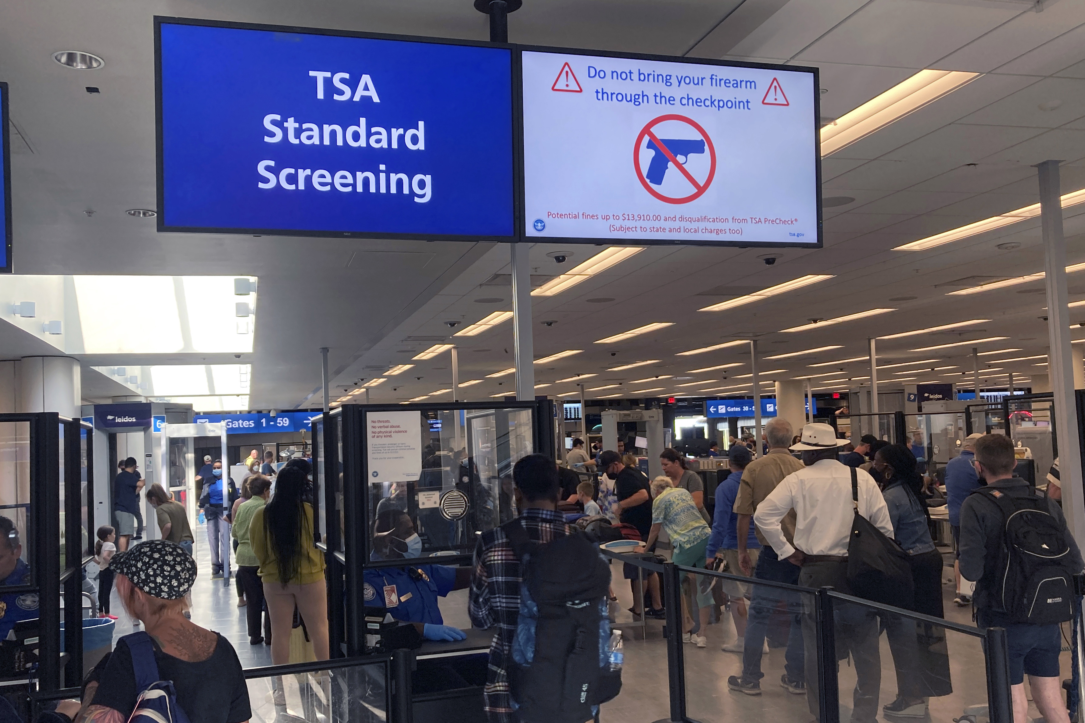 A sign warns travelers not to bring guns through the Transportation Security Administration checkpoint at Orlando International Airport in Orlando, Fla., on April 23. The TSA said Friday it is raising the fine for people caught with a gun in their carry-on bag to a maximum fine of $14,950 after intercepting a record number of firearms at security checkpoints this year. Previously it was $13,910.