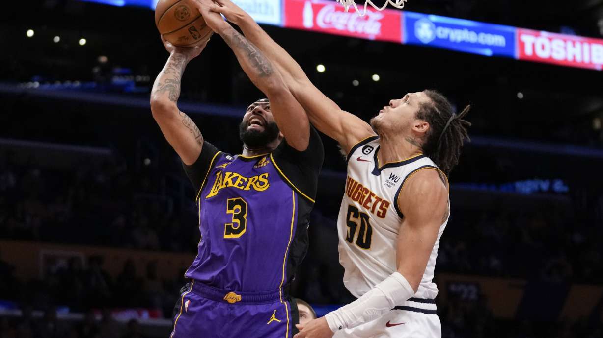 Los Angeles Lakers forward Anthony Davis (3) shoots against Denver Nuggets forward Aaron Gordon (50) during the first half of an NBA basketball game in Los Angeles, Friday, Dec. 16, 2022.