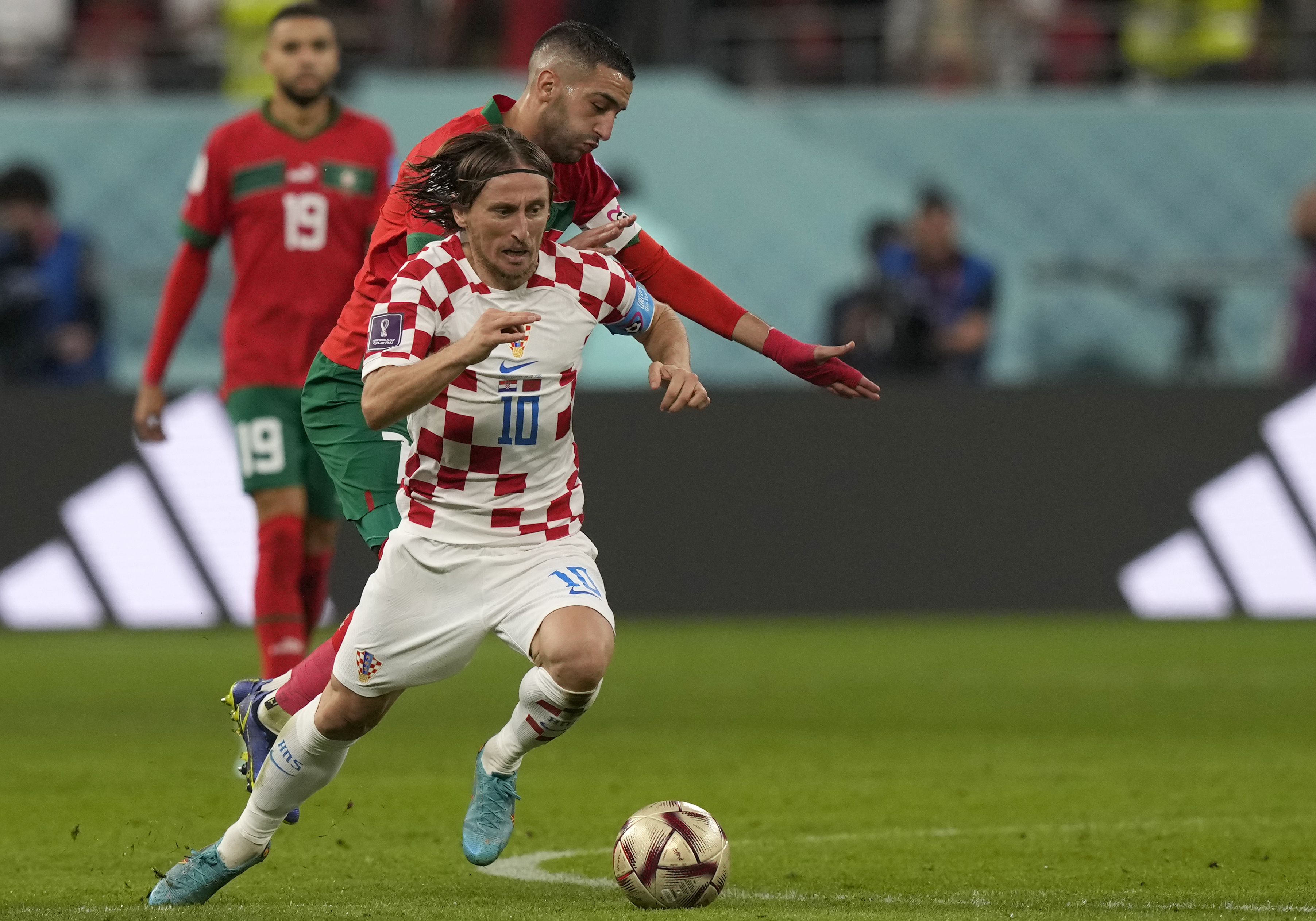 Croatia's Luka Modric, front, duels for the ball with Morocco's Hakim Ziyech during the World Cup third-place playoff soccer match between Croatia and Morocco at Khalifa International Stadium in Doha, Qatar, Saturday, Dec. 17, 2022. 