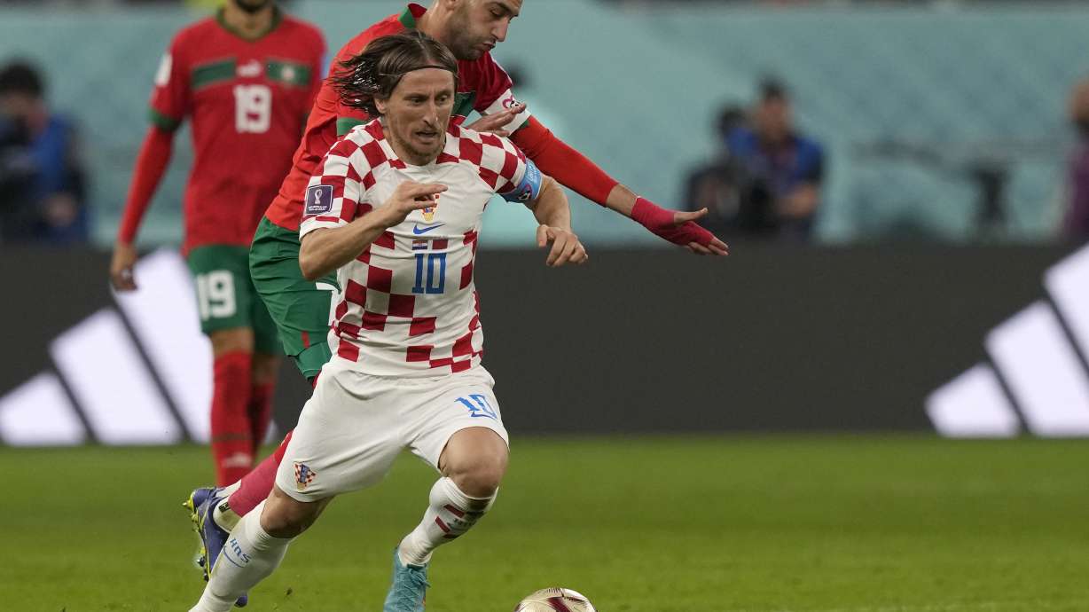 Croatia's Luka Modric, front, duels for the ball with Morocco's Hakim Ziyech during the World Cup third-place playoff soccer match between Croatia and Morocco at Khalifa International Stadium in Doha, Qatar, Saturday, Dec. 17, 2022.