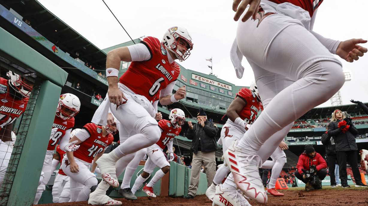 Louisville takes the field before the Fenway Bowl NCAA college football game against Cincinnati at Fenway Park, Saturday, Dec. 17, 2022, in Boston.