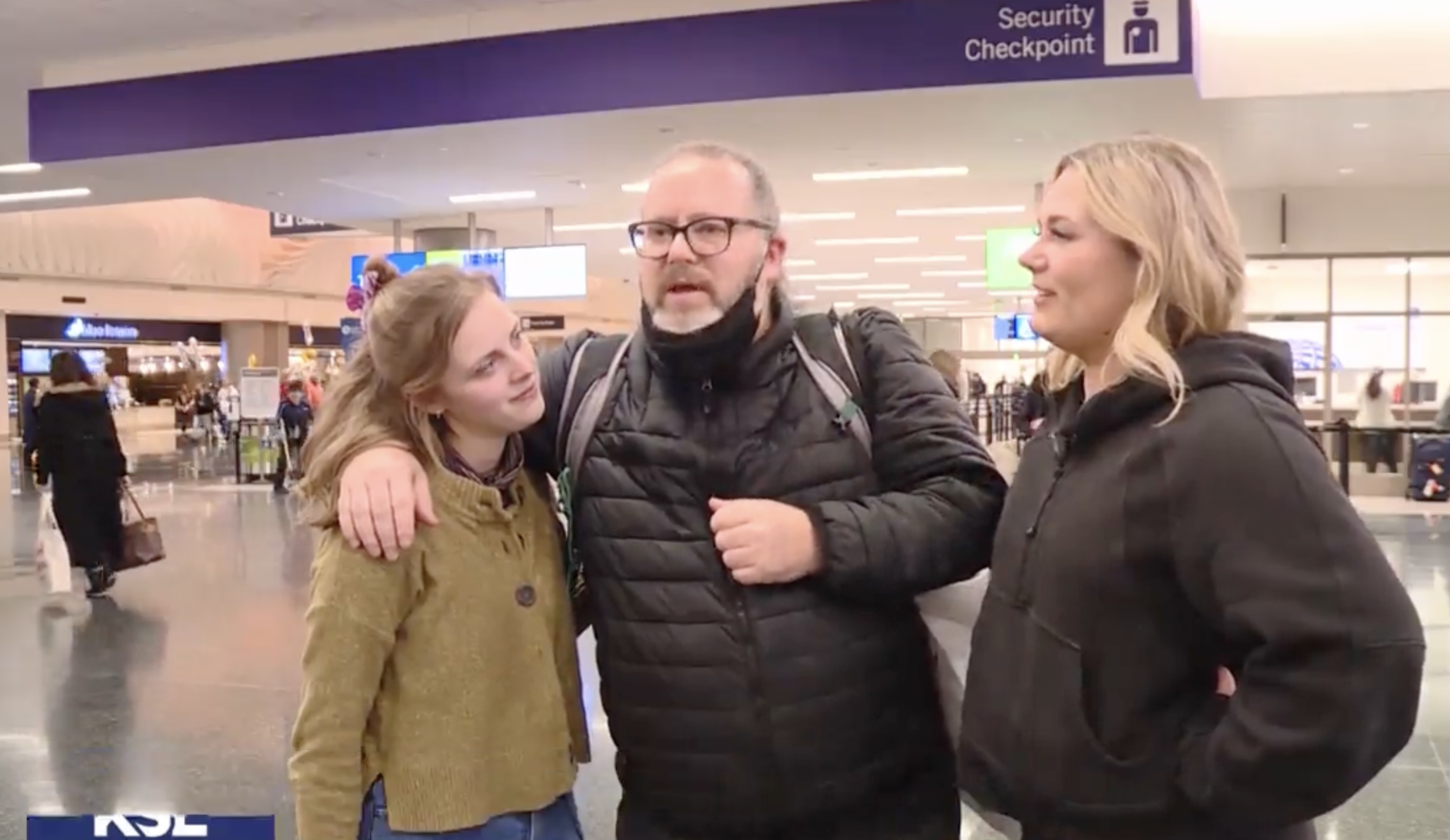 Chelsea Allgaier and Emsley Helms hug their father, David Allgaier, after waiting years for his return from China this week.