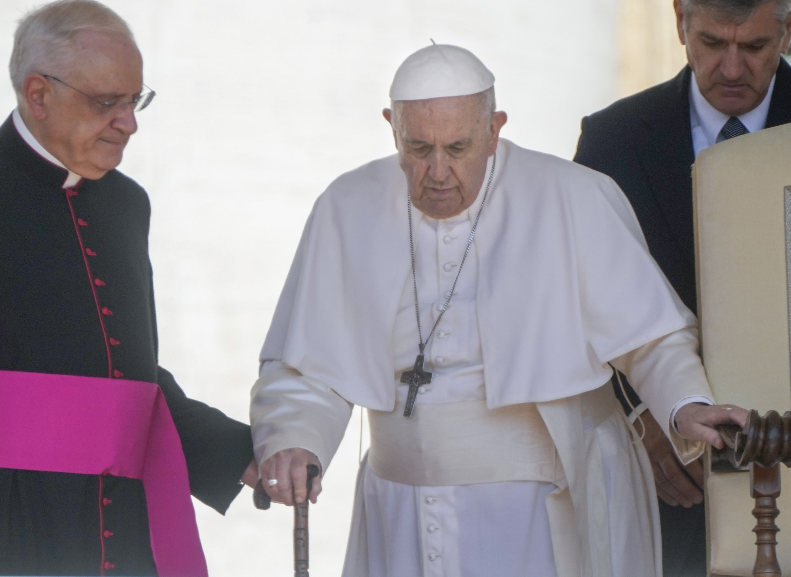 Pope Francis is helped by his aide Monsignor Leonardo Sapienza, left, as he walks with a cane to his weekly general audience in St. Peter's Square at the Vatican, on June 1. Pope Francis has revealed in an interview published Sunday that shortly after being elected pontiff in 2013 he wrote a resignation letter in case medical problems impede him from carrying out duties.