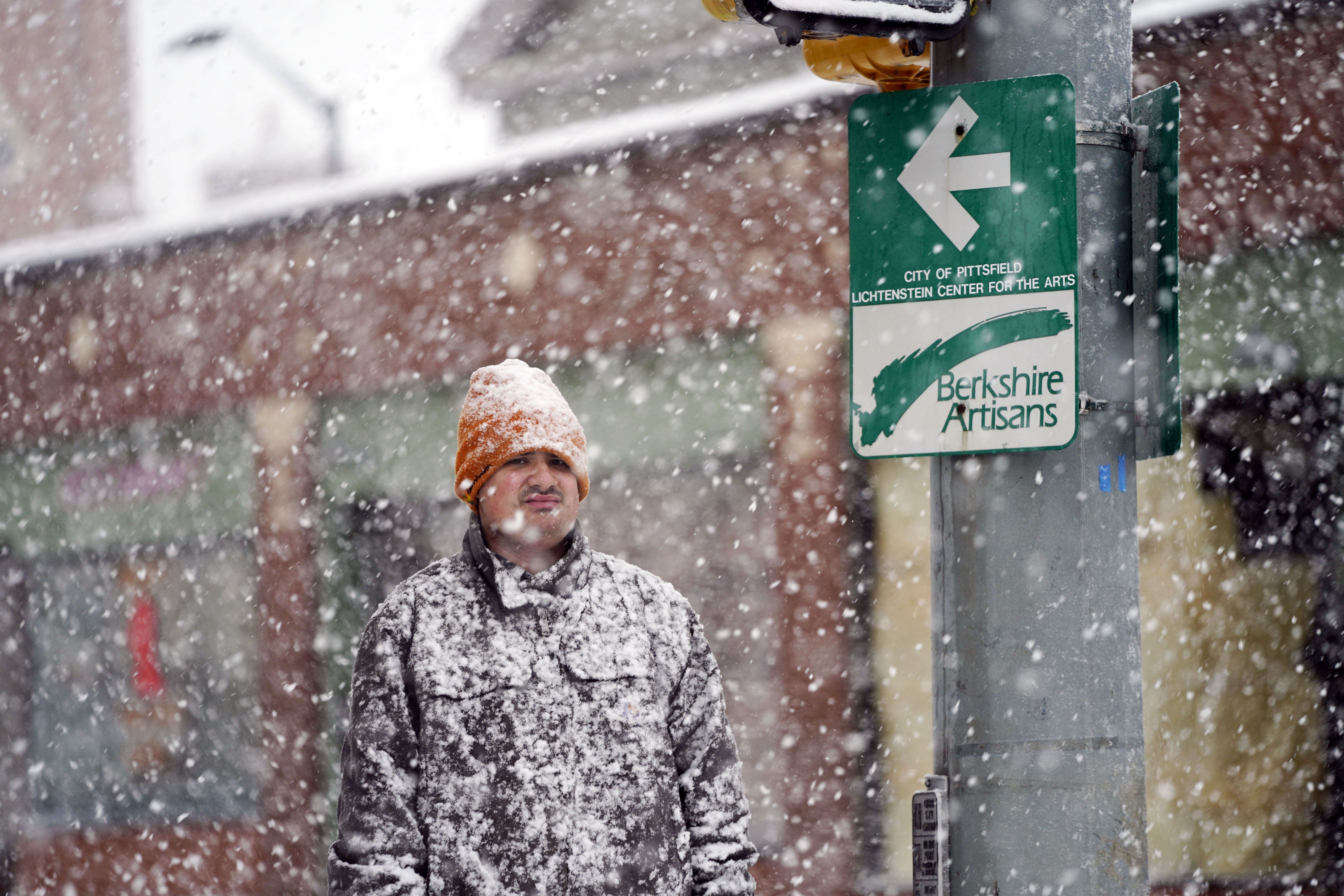 A man is covered in snow on Fenn Street in Pittsfield, Mass, Friday.