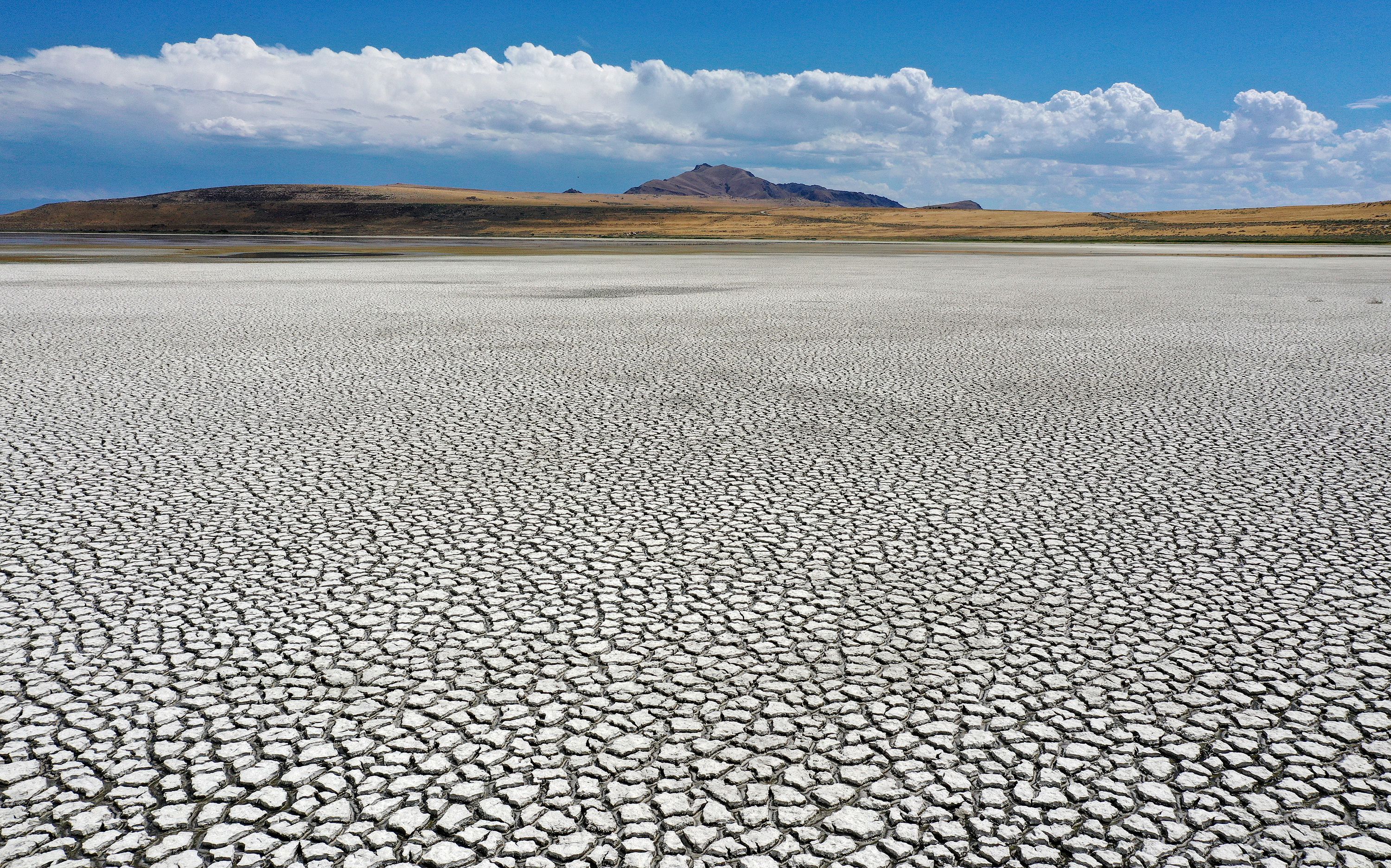 Dried lake bed is pictured in Farmington Bay, looking at Antelope Island, as the Great Salt Lake experiences record low water levels on July 22.