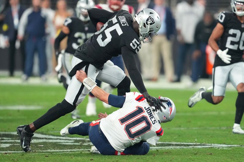 Dec 18, 2022; Paradise, Nevada, USA; Las Vegas Raiders defensive end Chandler Jones (55) stiff-arms New England Patriots quarterback Mac Jones (10) on the way to scoring a touchdown at the end of the second half at Allegiant Stadium.
