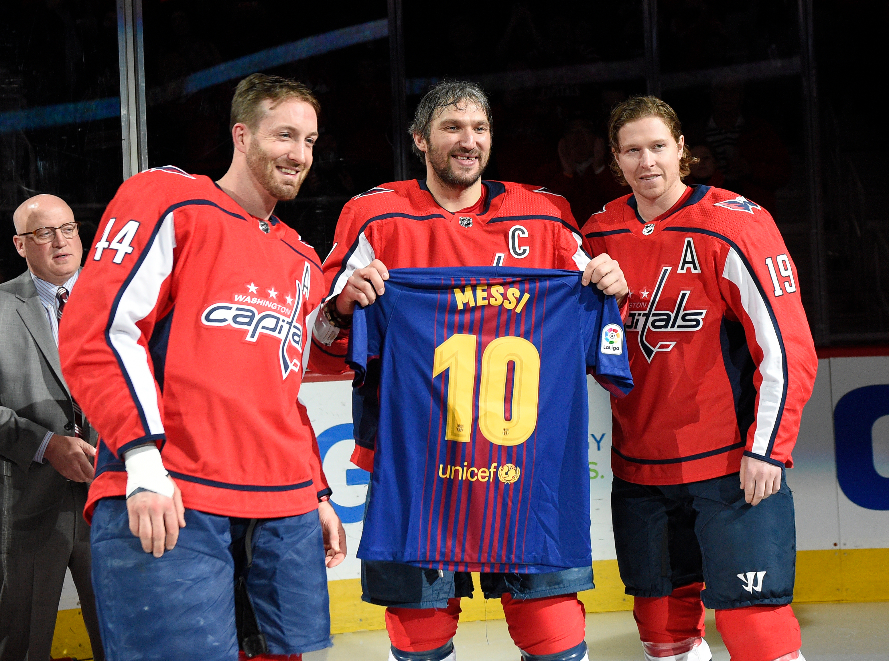 FILE - Washington Capitals left wing Alex Ovechkin, center, of Russia, poses with a Messi soccer jersey with Nicklas Backstrom (19), of Sweden, and Brooks Orpik (44) during a ceremony in honor of his 1,000th NHL hockey game, before the team's game against the Nashville Predators on Thursday, April 5, 2018, in Washington. The happiest professional athlete outside soccer about Lionel Messi winning the World Cup might be hockey star Alex Ovechkin. 