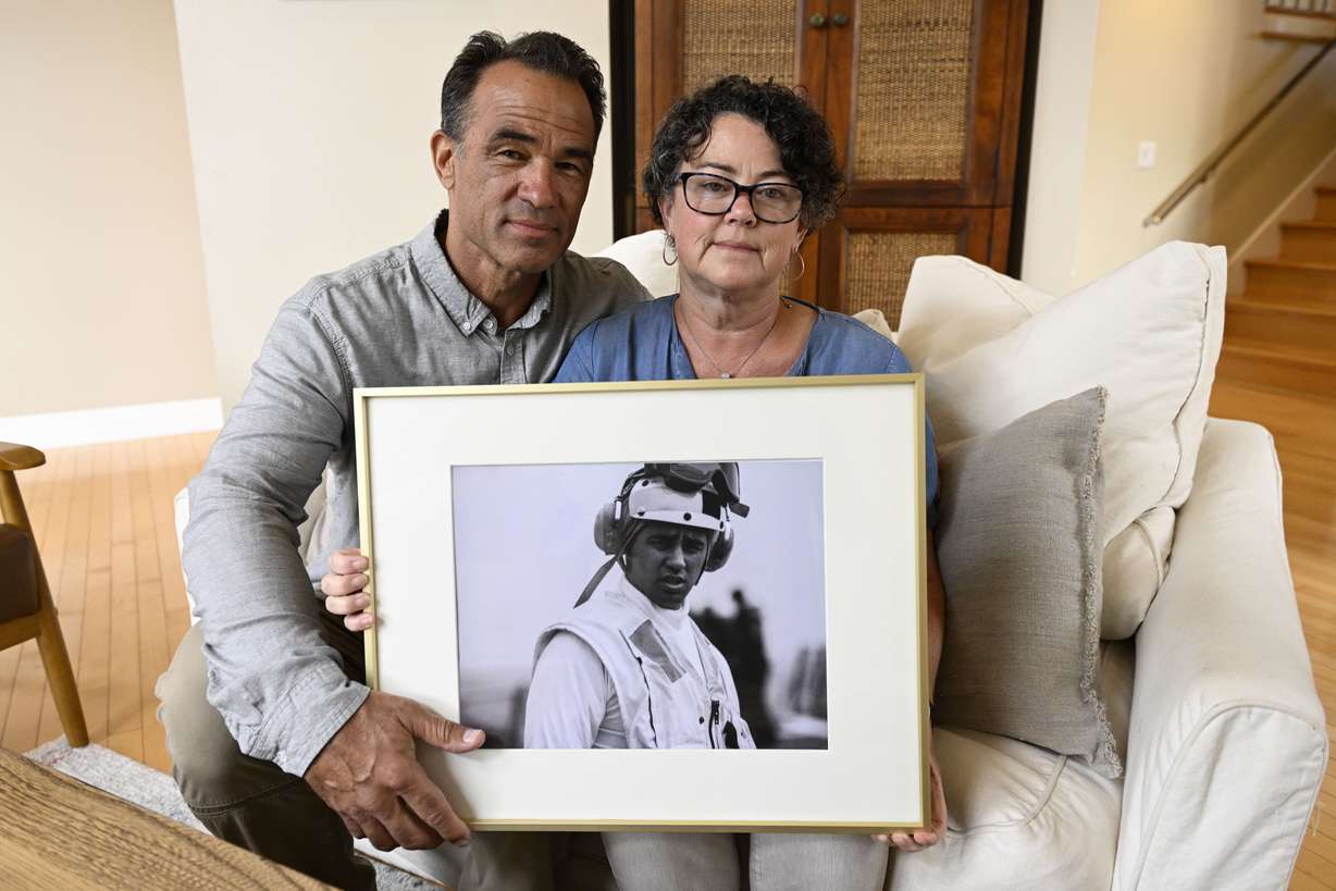 Derek and Suzi Alkonis pose with a photo of their son Lt. Ridge Alkonis on June 1, in Dana Point, Calif. Their son, a U.S. Navy lieutenant in Japan, was convicted of negligent driving in a deadly car crash and is serving a three-year prison sentence.