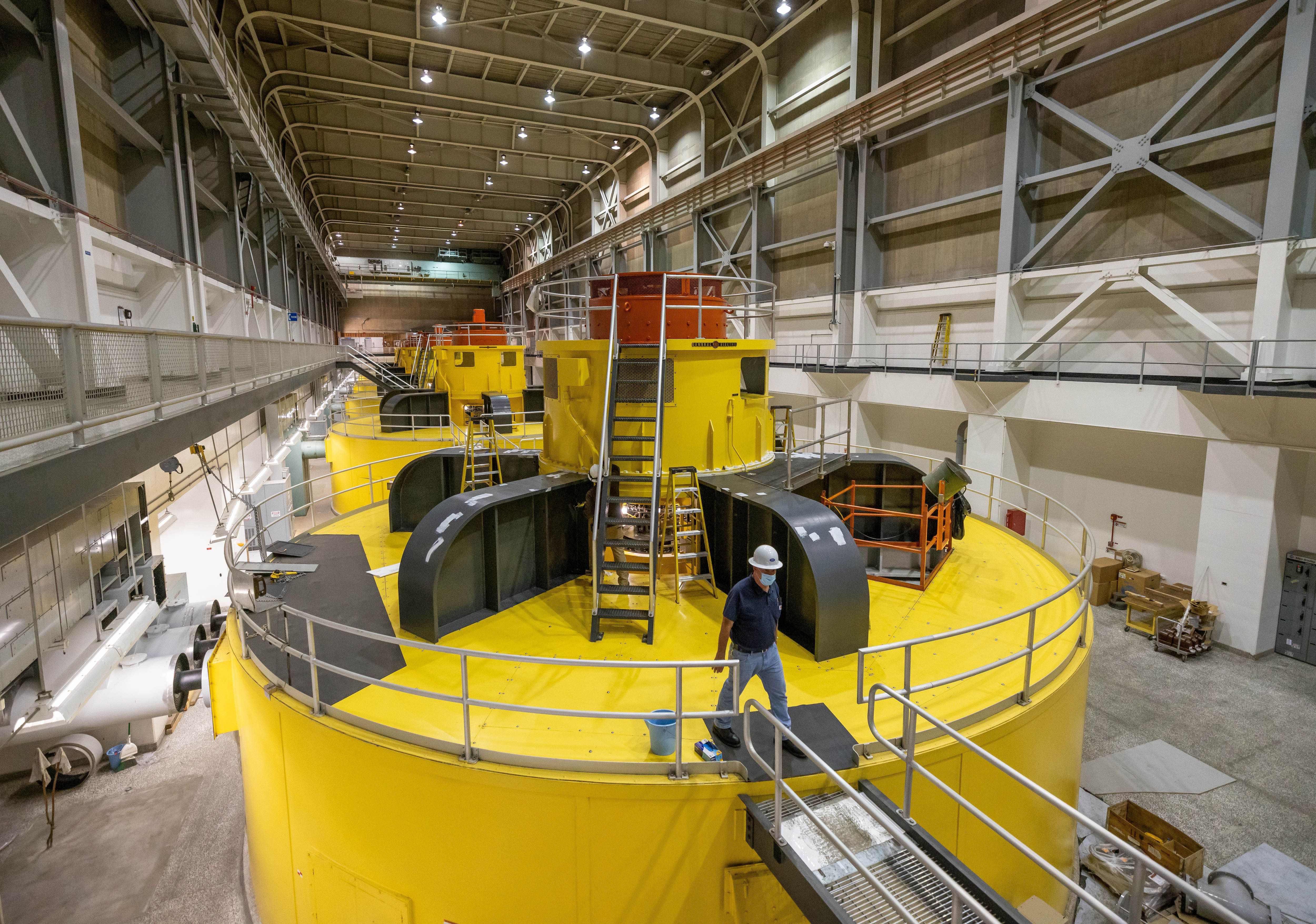 Acting facility manager Gus Levy walks on one of the massive power generators inside Glen Canyon Dam in Page, Ariz., on July 19.