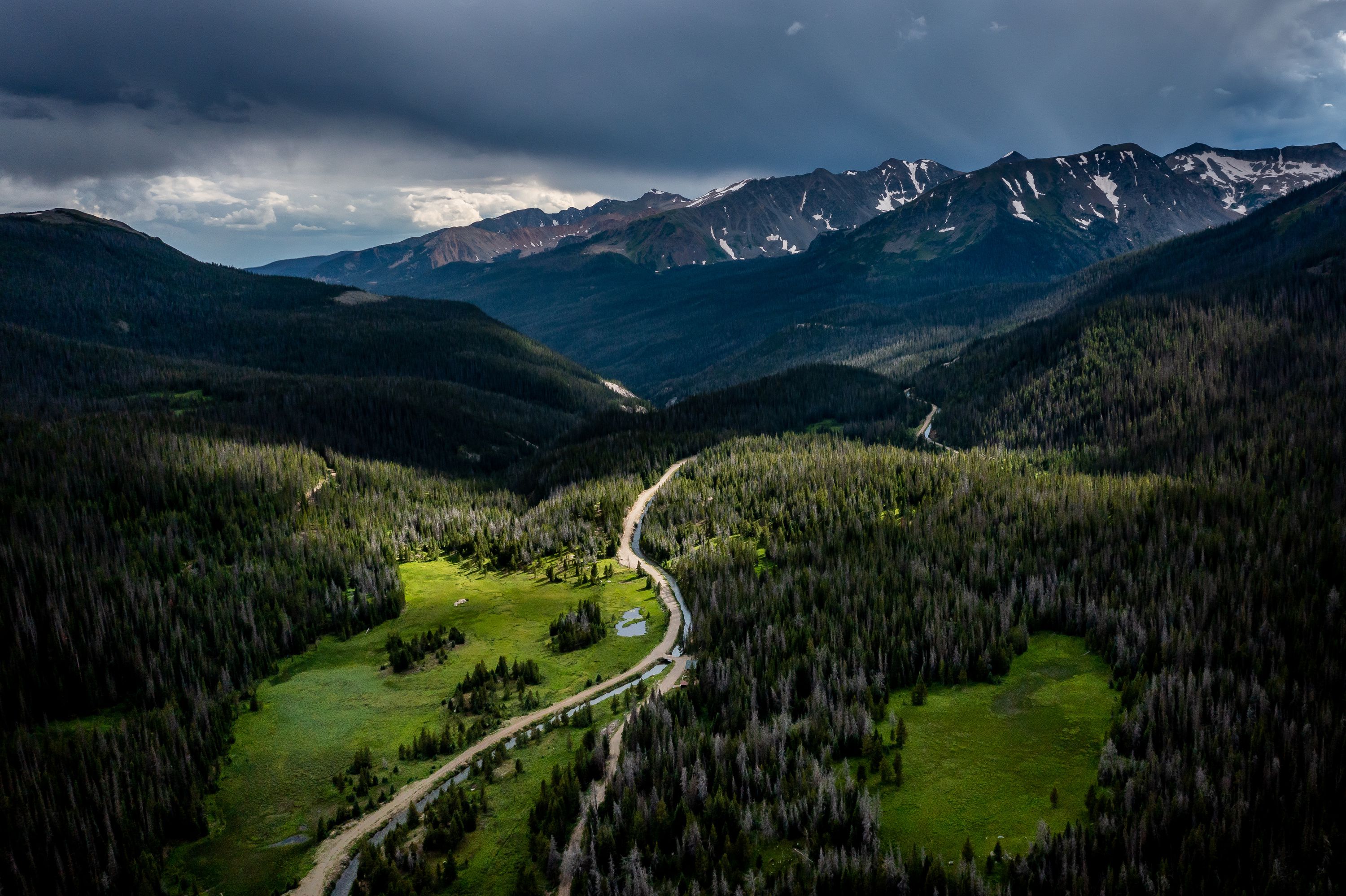 The headwater of the Colorado River, in the green meadow at left, is separated by a dirt road from the Grand Ditch in Colorado on July 14.