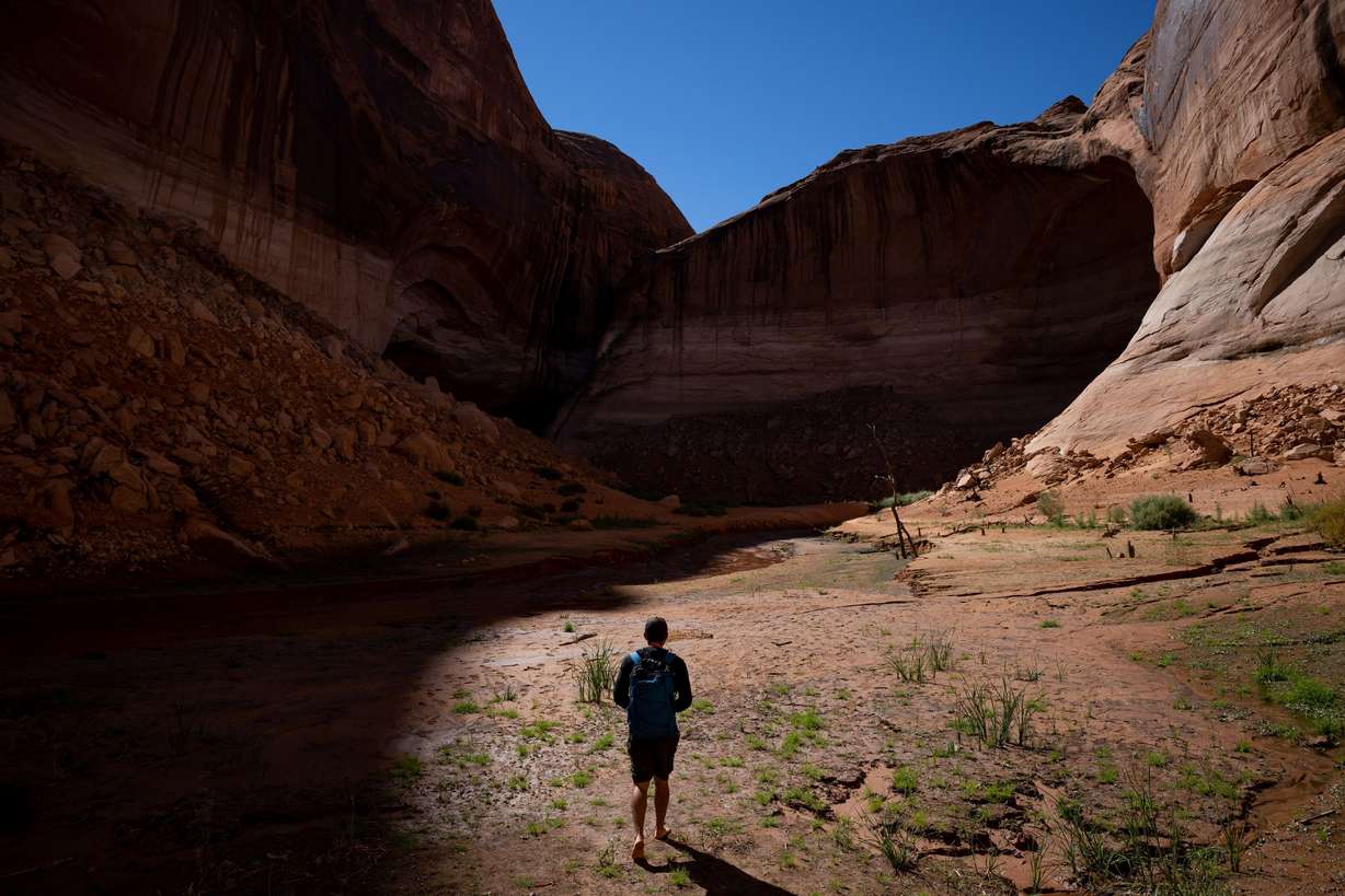 Eric Balken, executive director of Glen Canyon Institute, walks barefoot through Clear Creek Canyon, a side canyon off the Escalante River arm of Lake Powell, while on a media tour on Oct. 6. This portion of the canyon only recently emerged from the receding waters of the reservoir.