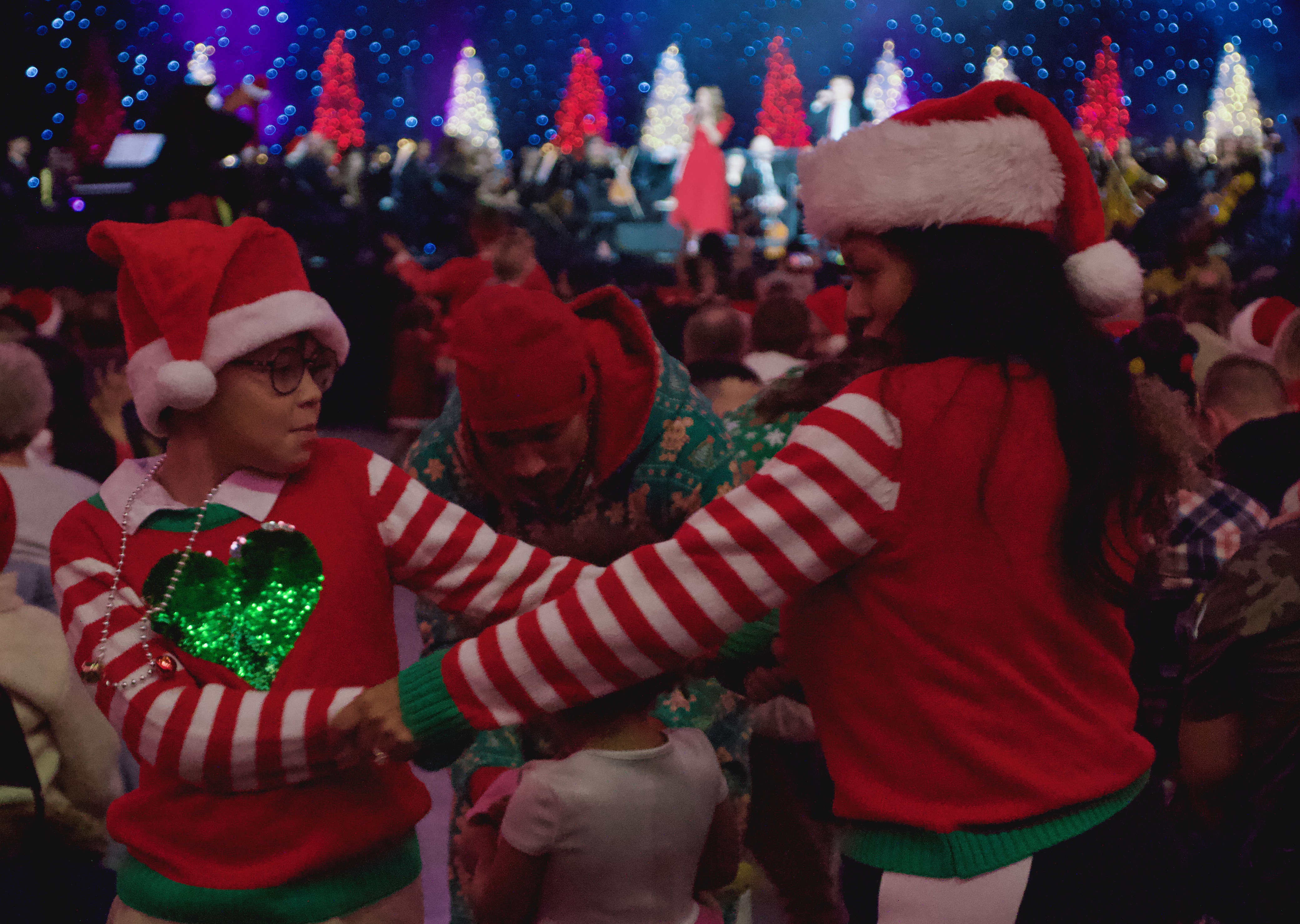 A family dances together at the 38th annual Larry H. Miller Christmas Carol Sing-Along at Vivint Arena on Wednesday.