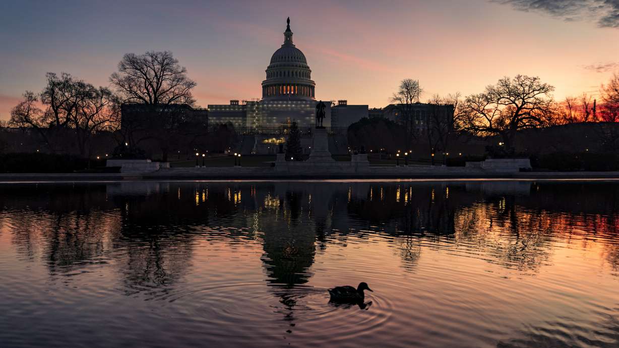 The sun rises behind the Capitol in Washington, early Dec. 14. Congressional leaders have unveiled a $1.7 trillion spending package early Tuesday that includes another large round of aid to Ukraine, a nearly 10% boost in defense spending and roughly $40 billon to assist communities across the country recovering from drought, hurricanes and other natural disasters.