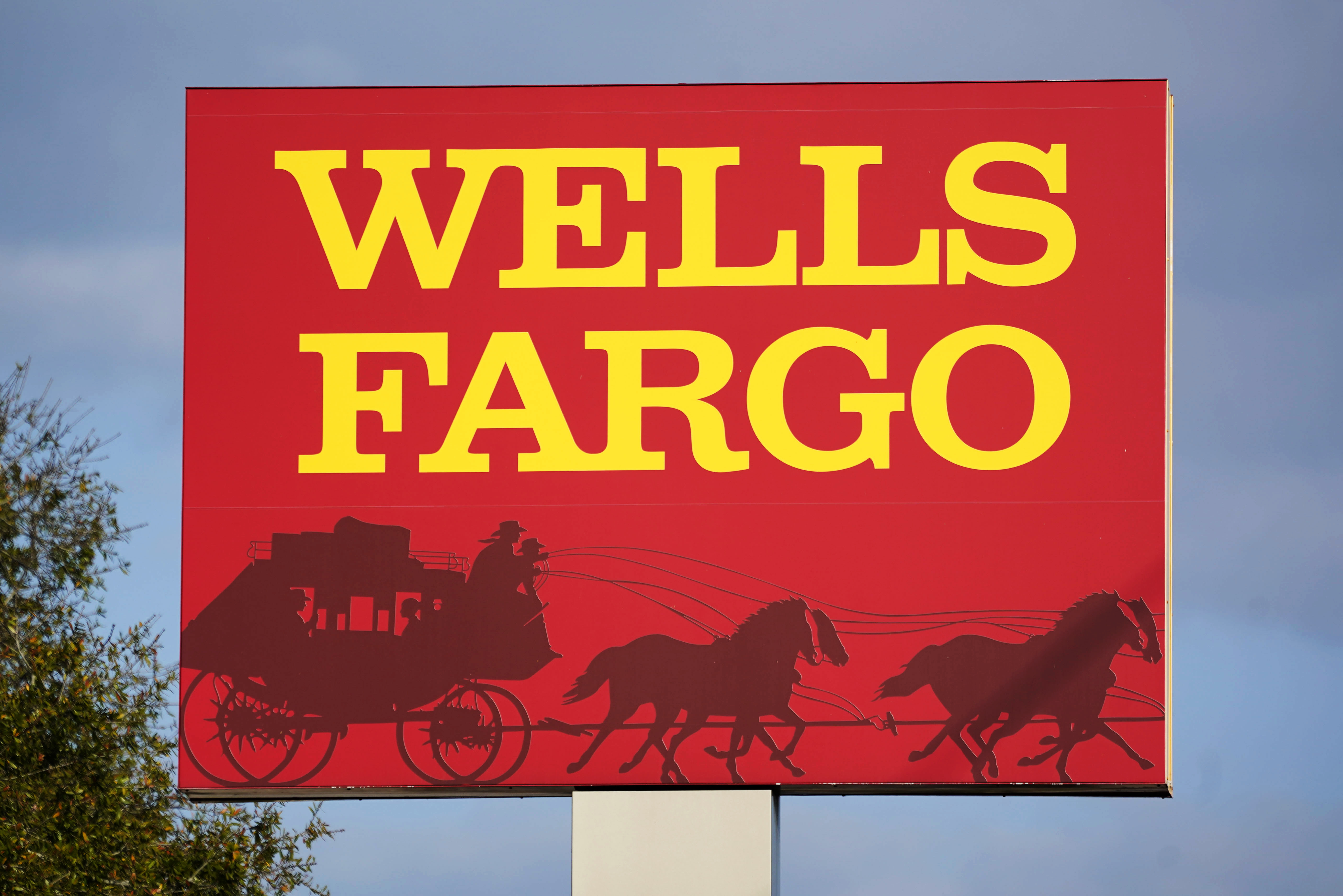 A Wells Fargo sign stands in front of a branch in Bradenton, Fla., Feb. 22. Wells Fargo is being ordered to pay $3.7 billion in fines and refunds to customers by U.S. government regulators, the largest fine to date against the bank. 
