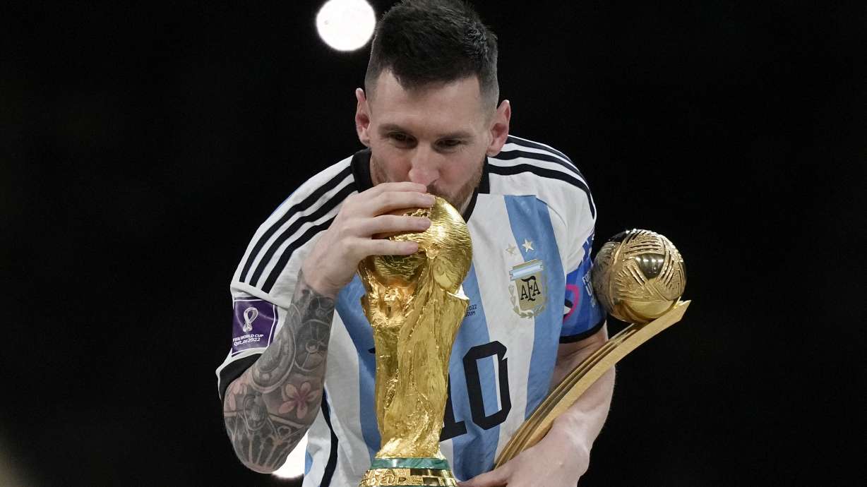 Argentina's Lionel Messi kisses the trophy after winning the World Cup final soccer match between Argentina and France at the Lusail Stadium in Lusail, Qatar, Sunday, Dec. 18, 2022. Argentina won 4-2 in a penalty shootout after the match ended tied 3-3.