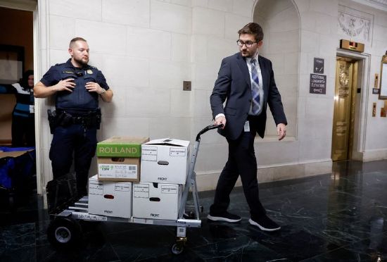 U.S. House Ways and Means Committee staff members transport boxes of documents after a committee meeting to discuss former President Donald Trump's tax returns on Capitol Hill in Washington, Tuesday.