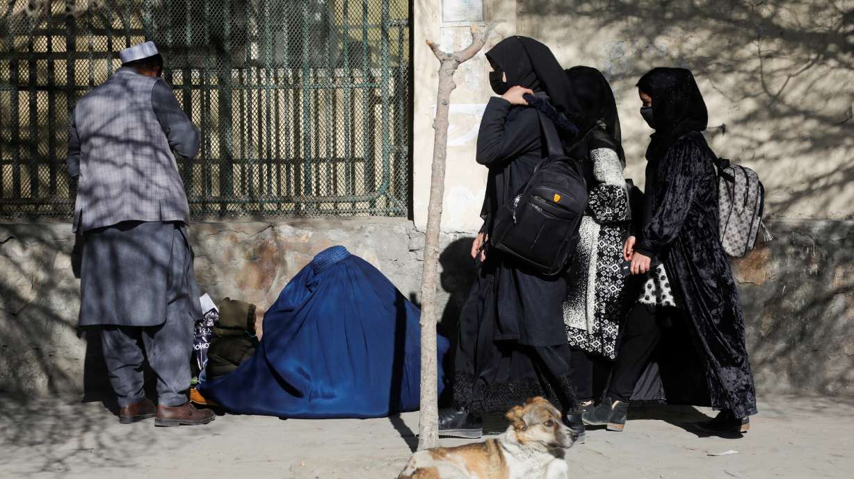 Afghan female students walk near Kabul University in Kabul, Afghanistan, Wednesday. Female university students in Afghanistan were turned away from campuses on Wednesday after the Taliban-run administration said women would be suspended from tertiary education.