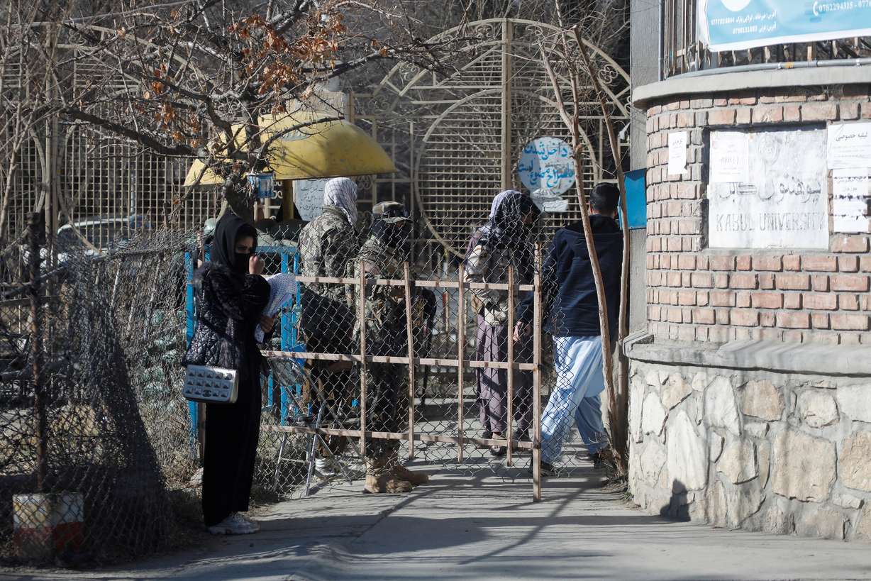 An Afghan female student stands in front of the entrance gate of Kabul University in Kabul, Afghanistan, Wednesday.