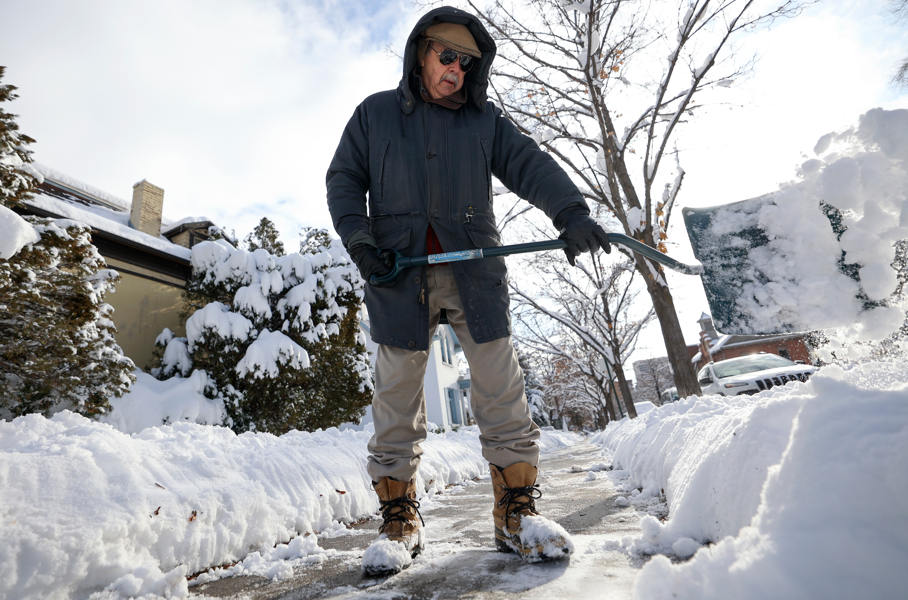 John Russell shovels the sidewalk in front of his house after a snowstorm in Salt Lake City on Dec. 15. Winter solstice is Wednesday afternoon in Utah.