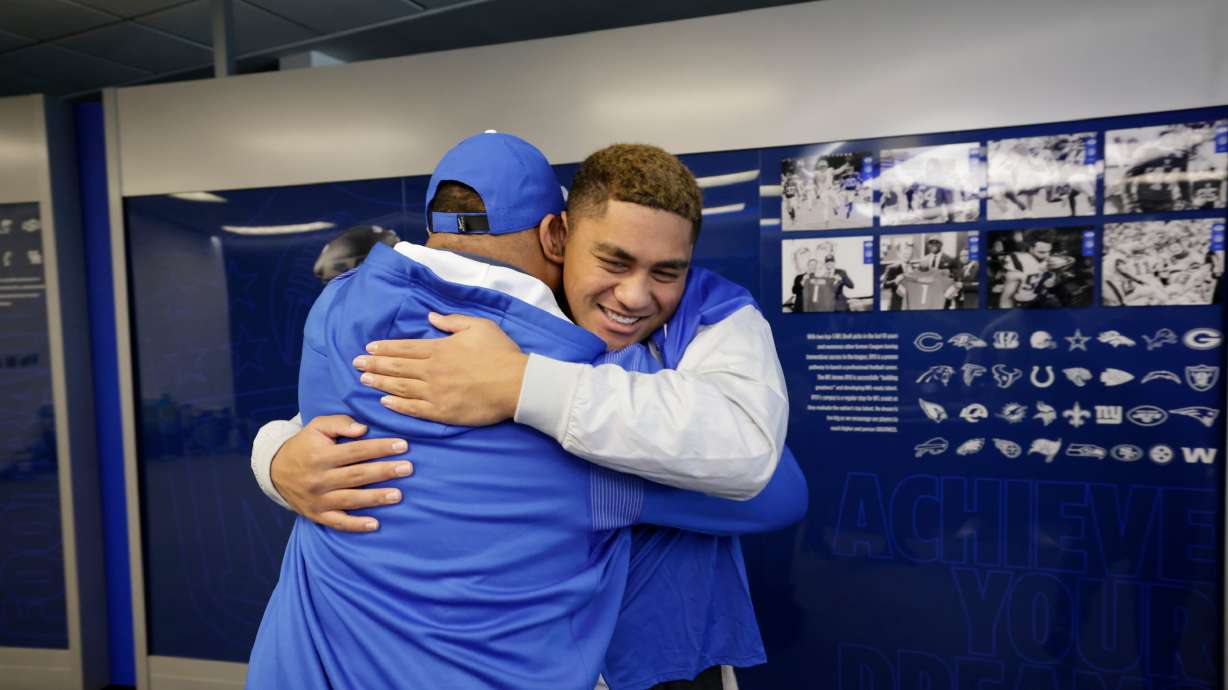 Timpview High edge rusher Siale Esera hugs his new coach, BYU's Kalani Sitake, after signing with the Cougars on the first day of the early signing period, Wednesday, Dec. 21, 2022 in Provo.