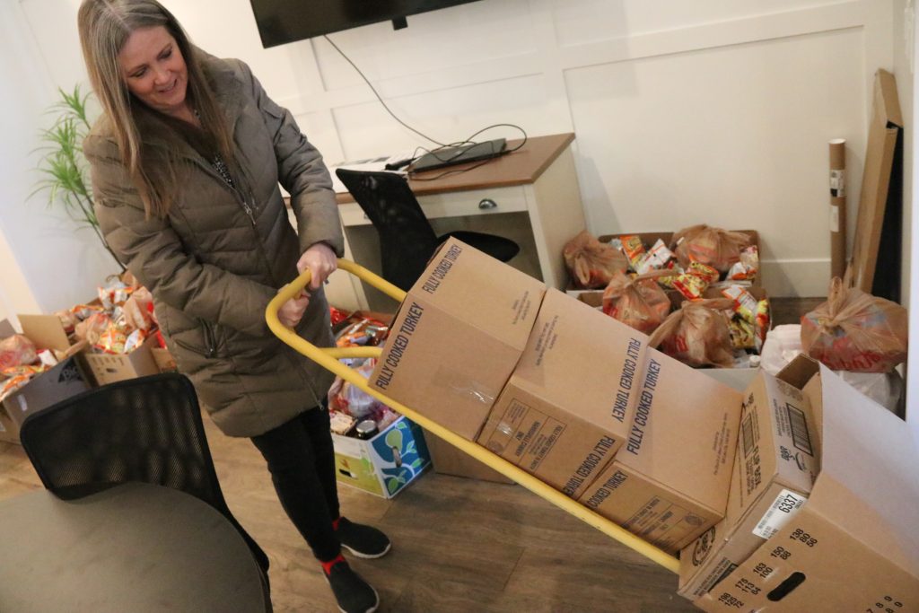Iron County Board of Realtors President Mary Ann Sharp brings in perishable items to be placed into food boxes, Cedar City, Utah, Monday.