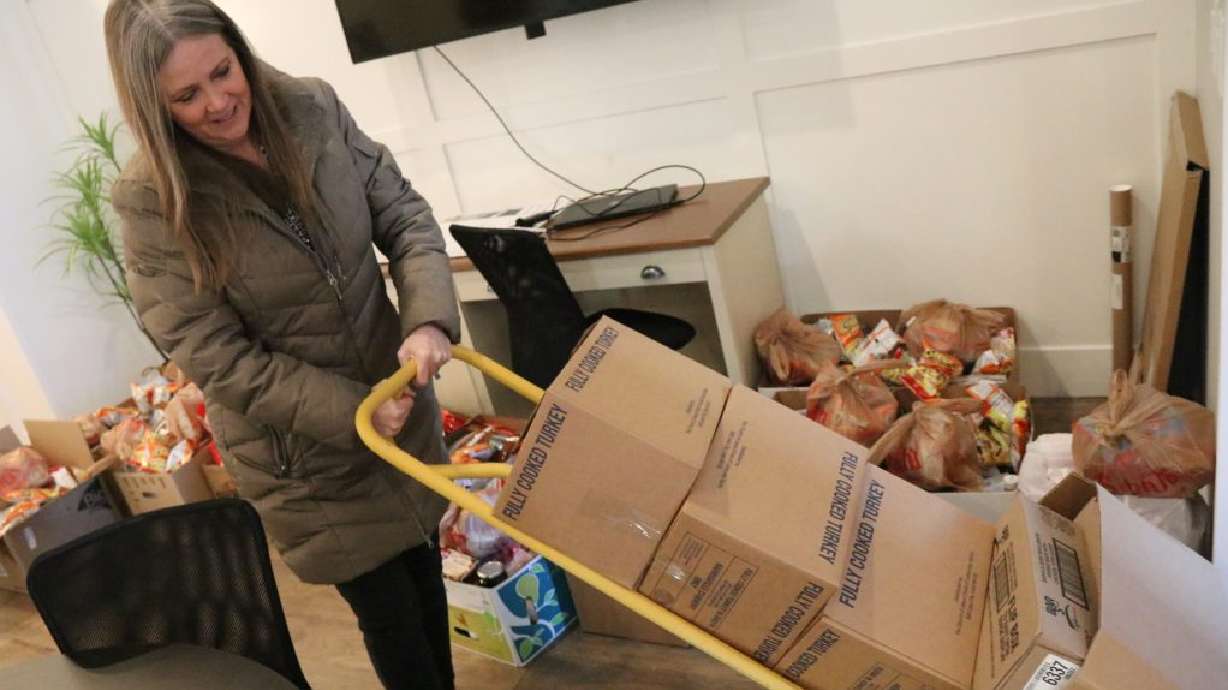 Iron County Board of Realtors President Mary Ann Sharp brings in perishable items to be placed into food boxes, Cedar City, Utah, Monday.