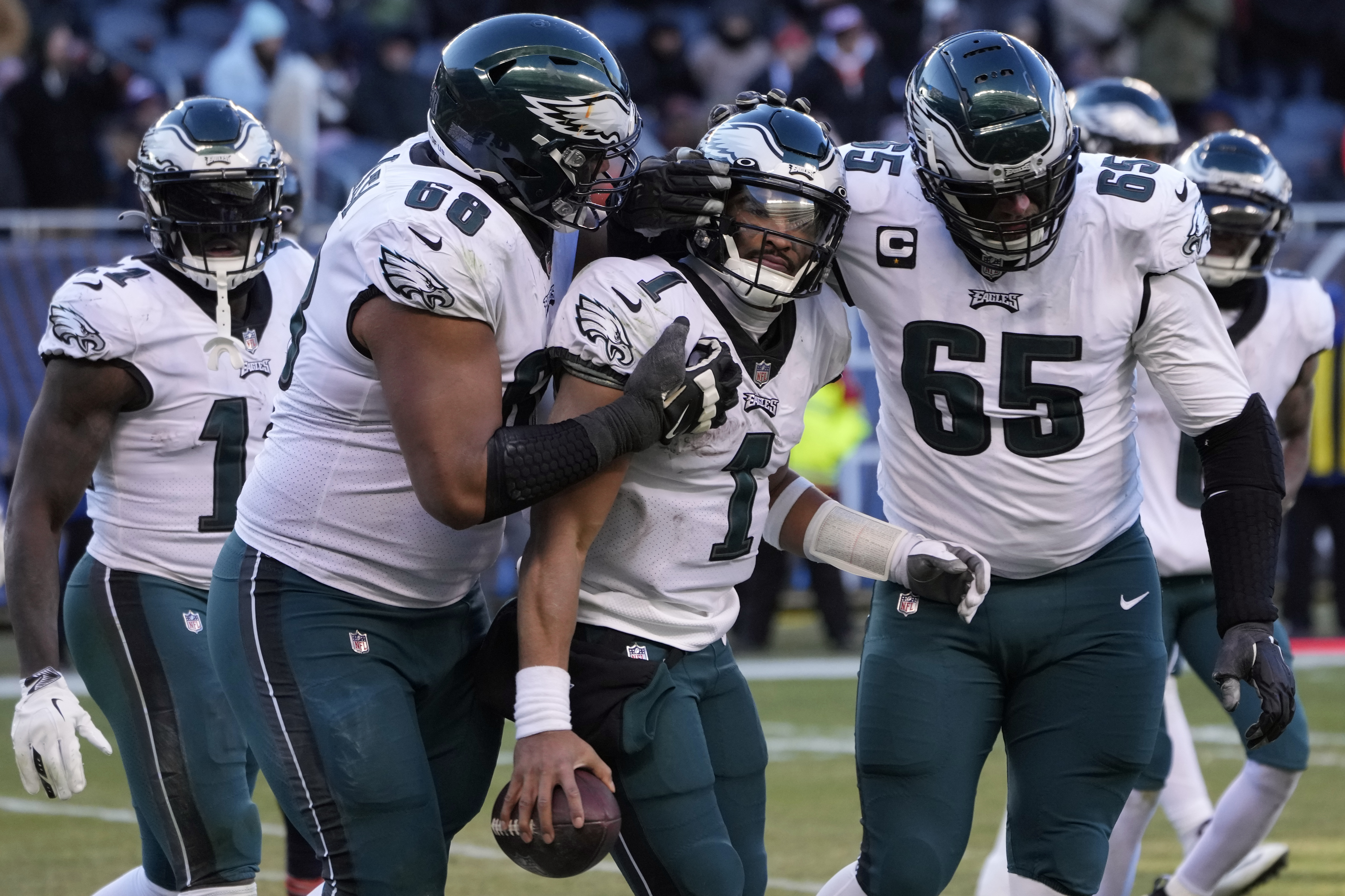 Philadelphia Eagles' Jalen Hurts (1) celebrates with Lane Johnson (65) and Jordan Mailata (68) after running for a two-point conversion during the second half of an NFL football game against the Chicago Bears, Sunday, Dec. 18, 2022, in Chicago. 