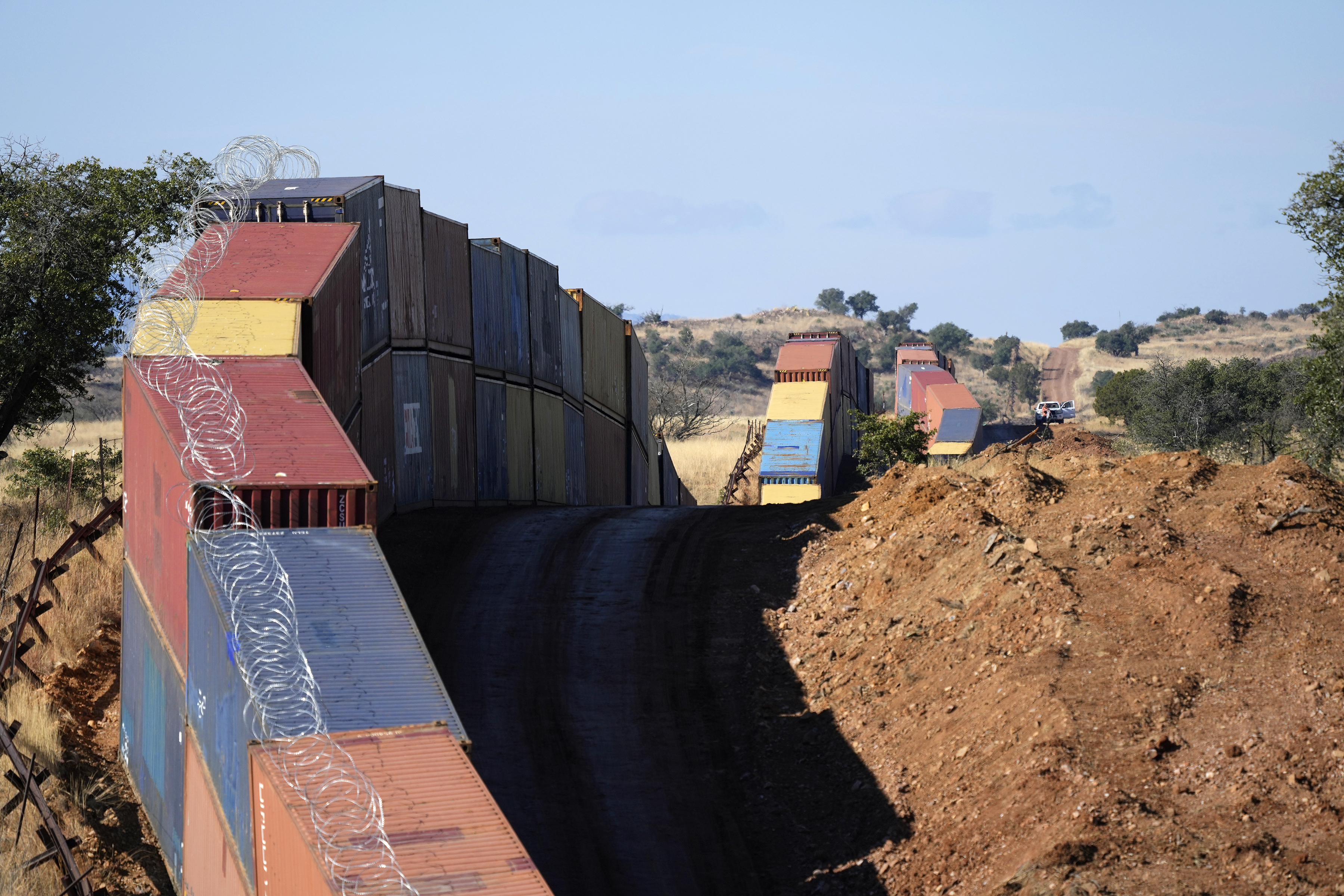 A long row of double-stacked shipping containers provides a new wall between the United States and Mexico in the remote section area of San Rafael Valley, Ariz., Dec. 8. Arizona Gov. Doug Ducey will take down the wall, settling a lawsuit with the U.S. government over trespassing on federal lands. 