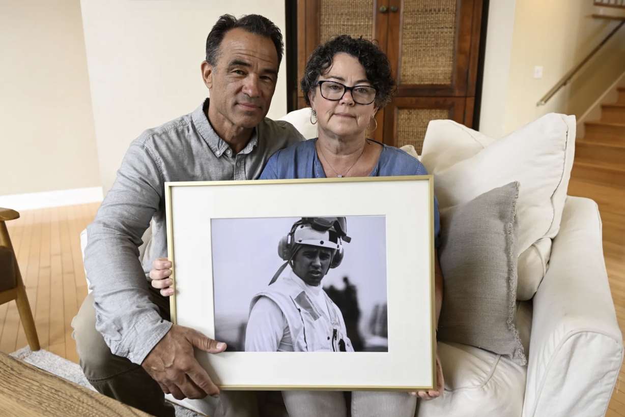 Derek and Suzi Alkonis pose with a photo of their son Lt. Ridge Alkonis on June 1 in Dana Point, Calif. Their son, a U.S. Navy lieutenant in Japan, was convicted of negligent driving in a deadly car crash and is serving a three-year prison sentence.