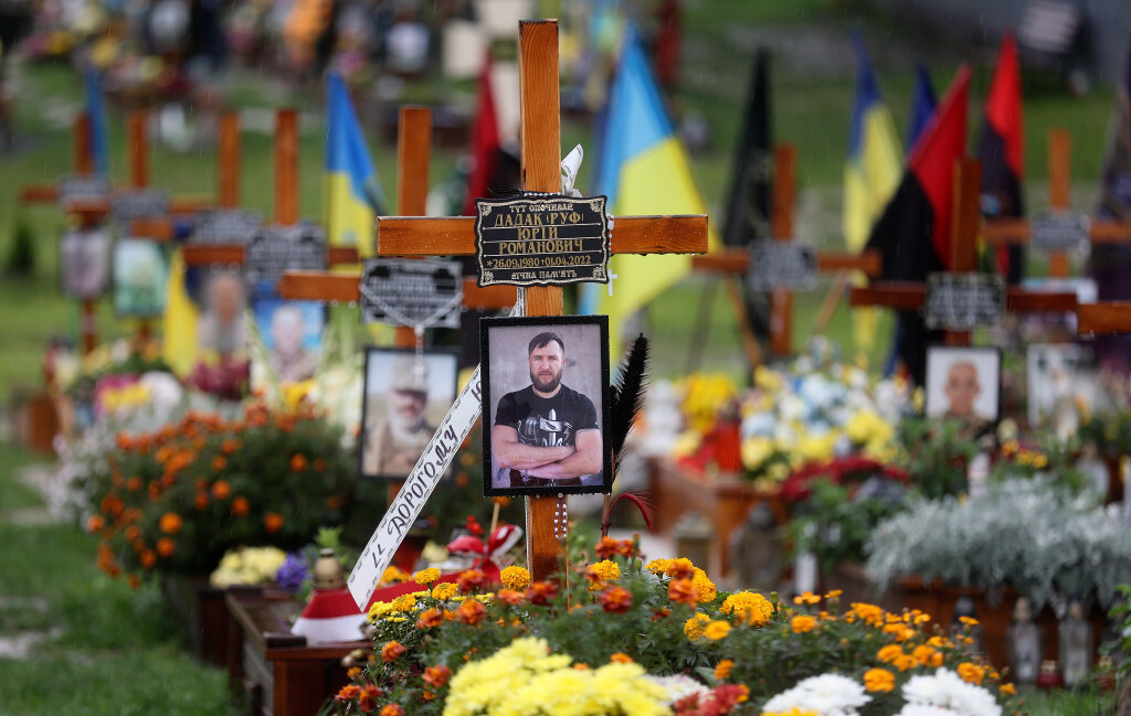 Graves of Ukrainian soldiers killed during the war with Russia are decorated with flowers, flags and photos in an overflow area just outside the fence of the historic Lychakiv Cemetery in Lviv, Ukraine, on Sept. 18. In Mariupol, Russian soldiers, builders, administrators and doctors are replacing the thousands of Ukrainians who have died or left. 
