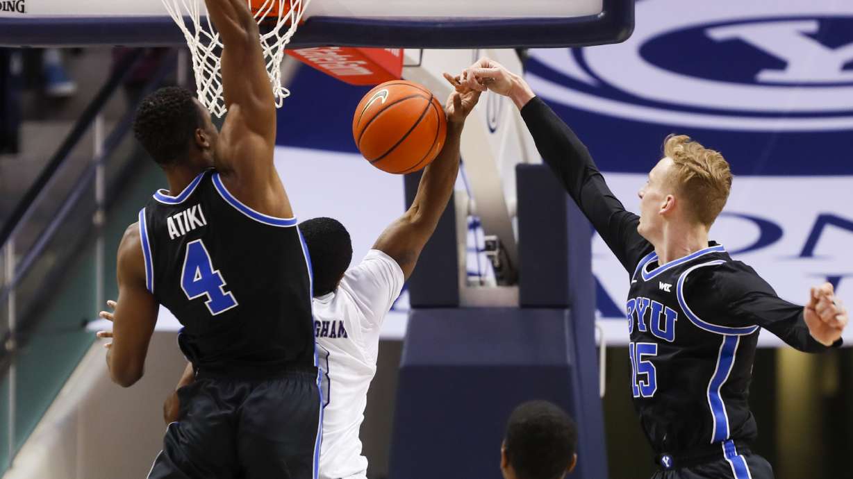 Weber State guard KJ Cunningham shot is stopped by BYU Cougars guard Richie Saunders in Provo on Thursday, Dec. 22, 2022. BYU won 63-57.