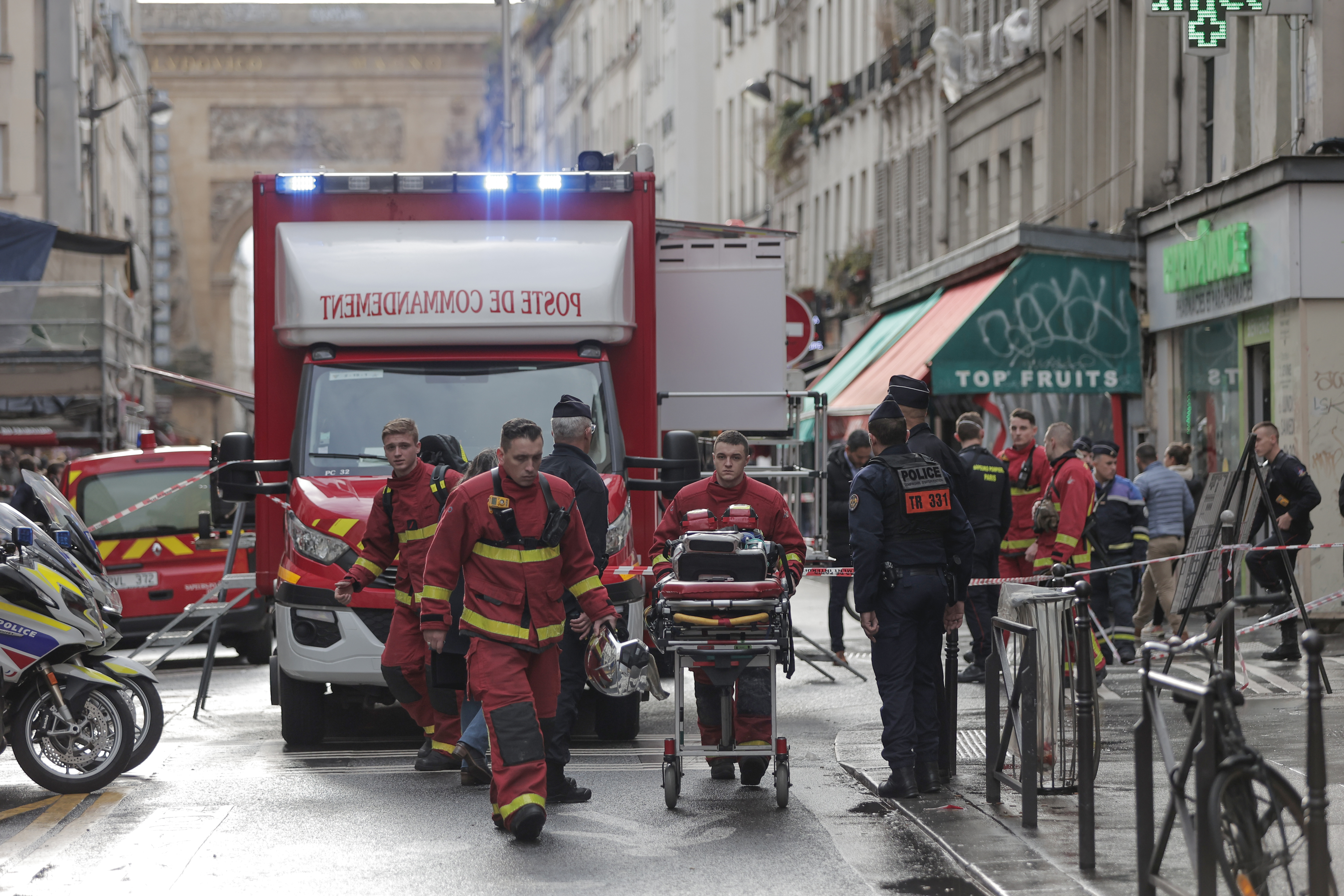 Fire brigade medics work on the scene where a shooting took place in Paris, Friday.
