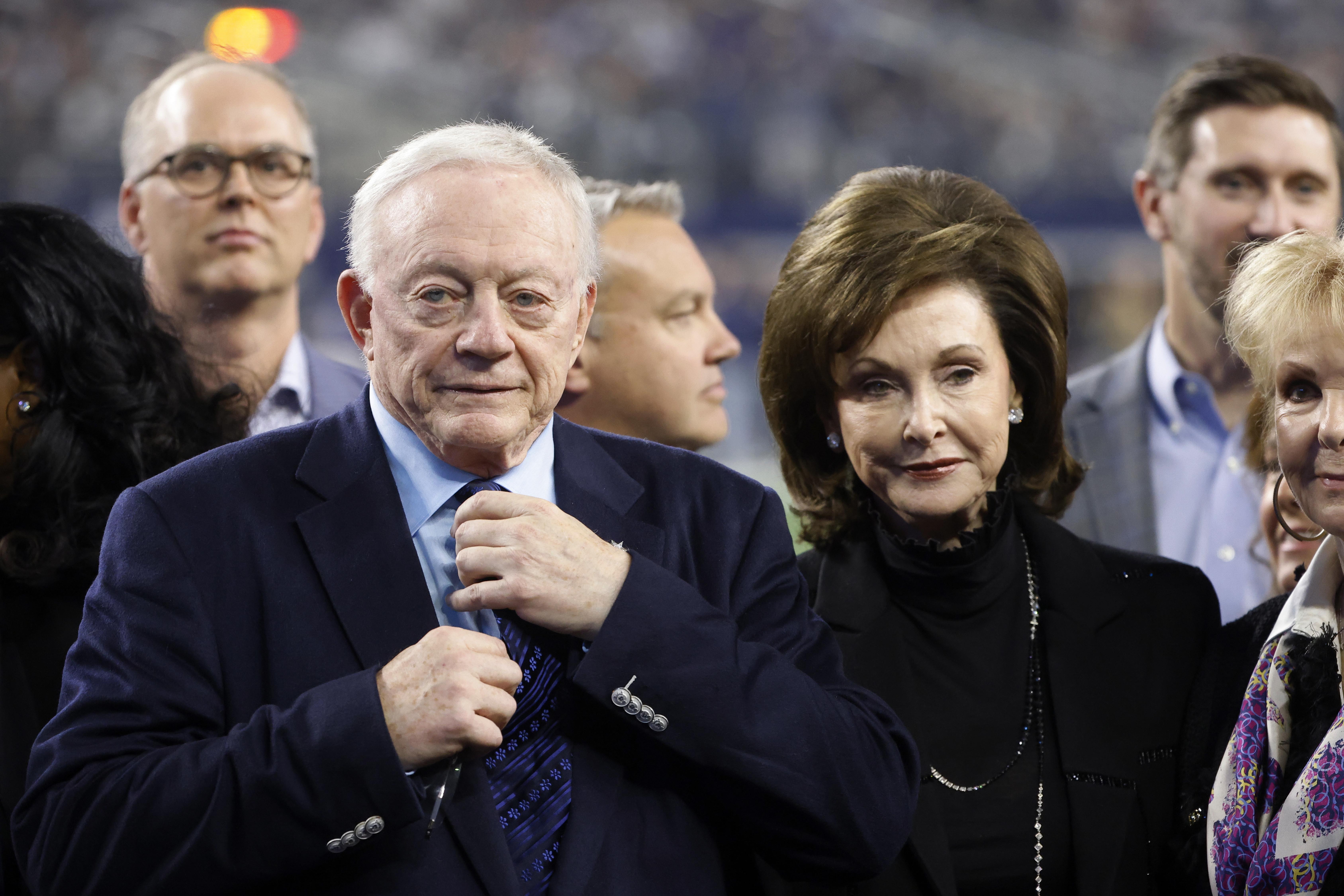 FILE -Dallas Cowboys owner Jerry Jones and his wife Gene Jones, right, on the field during an NFL Football game in Arlington, Texas, Sunday, Dec. 4, 2022. A judge has ordered Dallas Cowboys owner Jerry Jones to take a paternity test as part of a legal dispute with a 26-year-old woman who claims the billionaire is her biological father. A Texas judge issued the order for genetic testing Thursday, Dec. 22, 2022 in a paternity case brought by Alexandra Davis. 