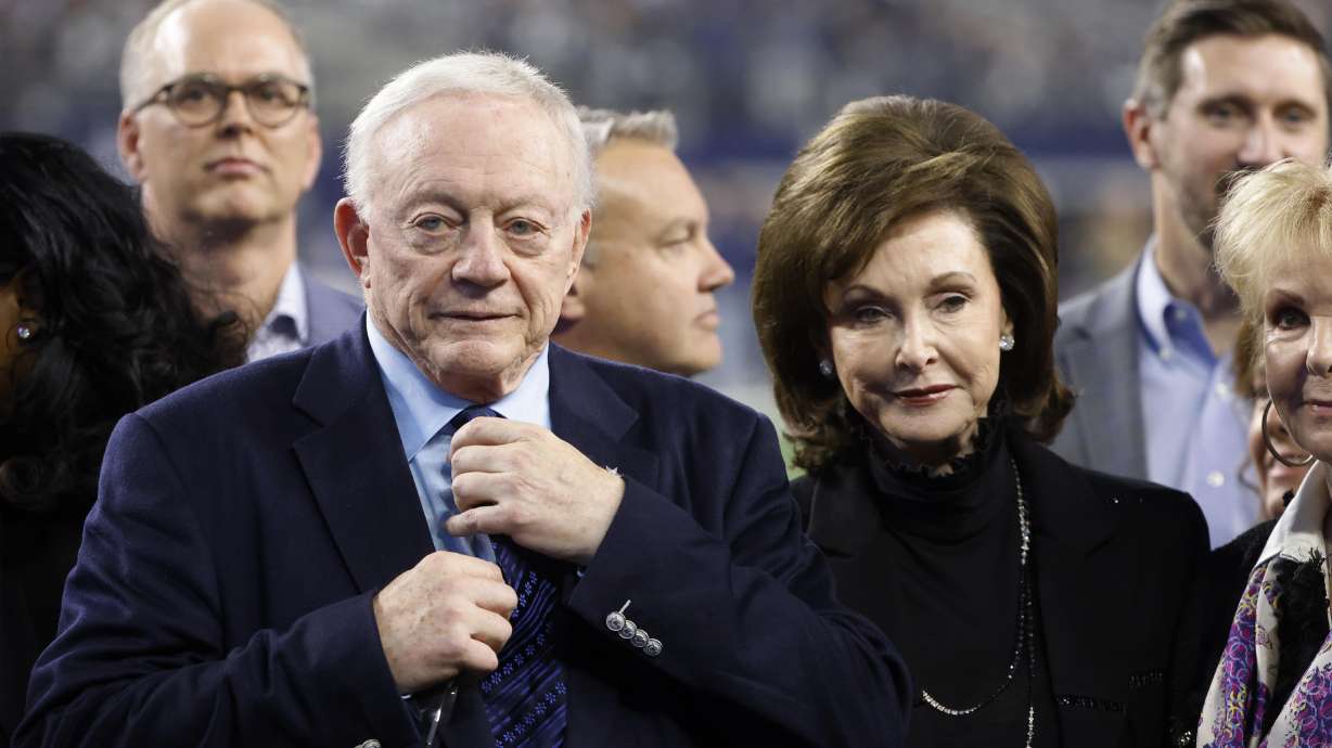 FILE -Dallas Cowboys owner Jerry Jones and his wife Gene Jones, right, on the field during an NFL Football game in Arlington, Texas, Sunday, Dec. 4, 2022. A judge has ordered Dallas Cowboys owner Jerry Jones to take a paternity test as part of a legal dispute with a 26-year-old woman who claims the billionaire is her biological father. A Texas judge issued the order for genetic testing Thursday, Dec. 22, 2022 in a paternity case brought by Alexandra Davis.