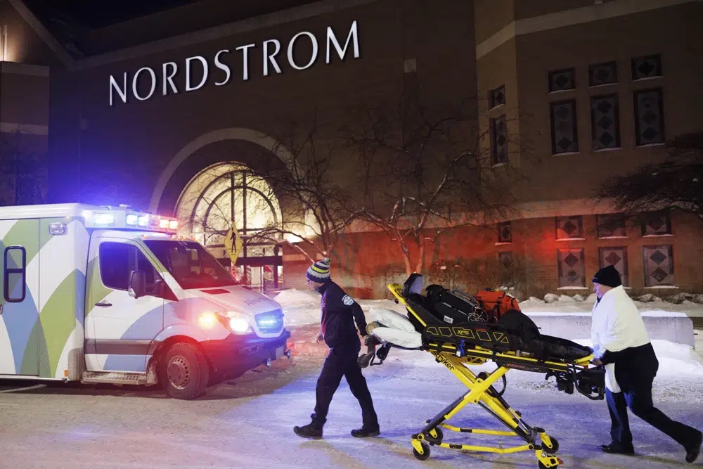 Two first responders and an ambulance are seen at the entrance to Nordstrom at the Mall of America in Bloomington, Minn., after reports of shots fired on Friday.