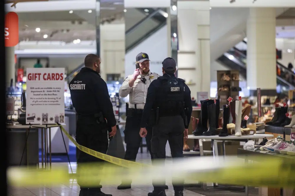 Security officers speak inside a store at the Mall of America in Bloomington, Minn., after reports of shots fired on Friday.