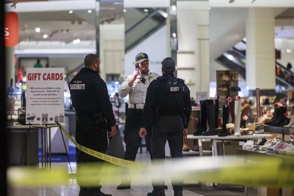 Security officers speak inside a store at the Mall of America in Bloomington, Minn., after reports of shots fired on Friday.