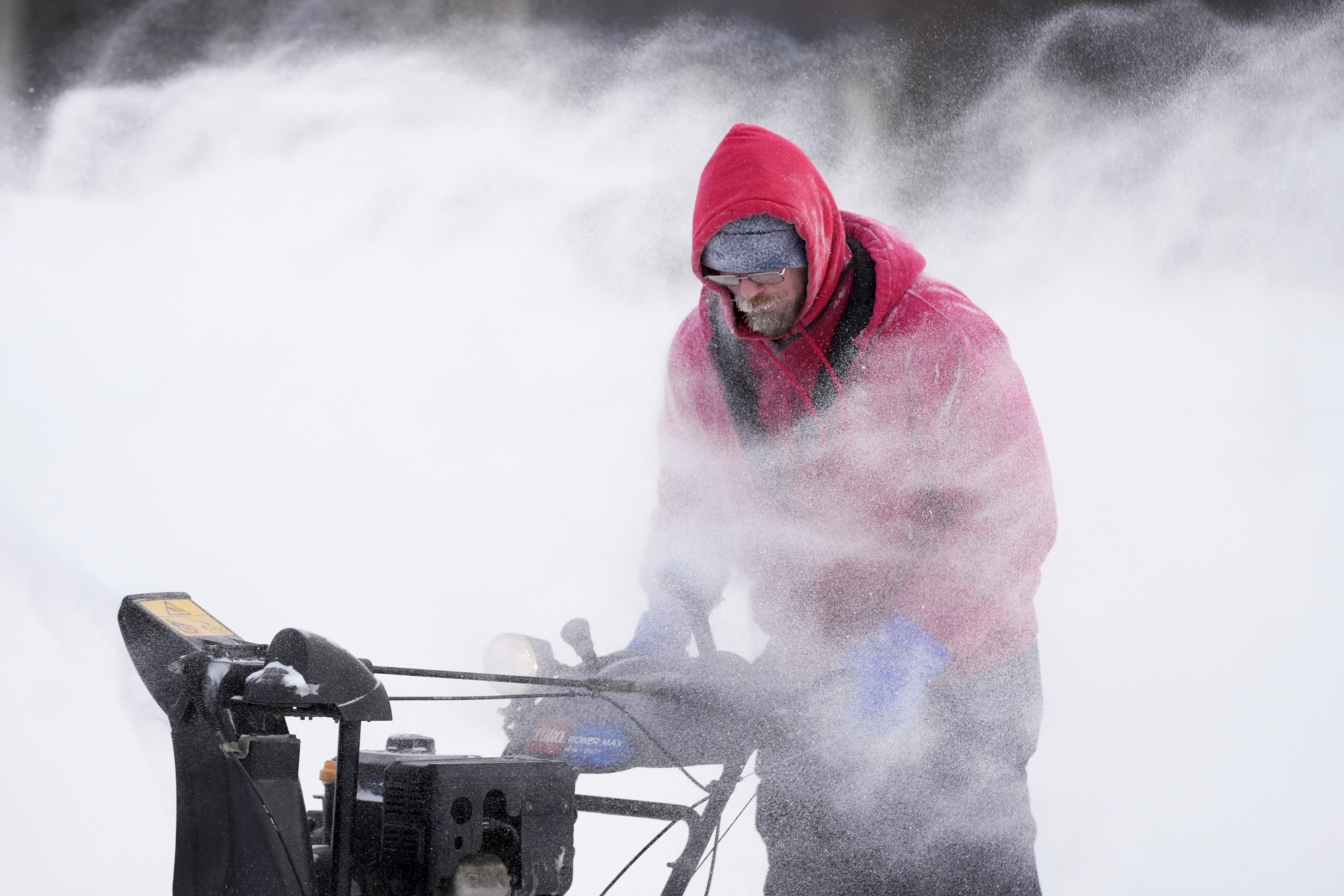 Mark Sorter clears snow from a downtown ice skating rink, Friday, in Des Moines, Iowa.