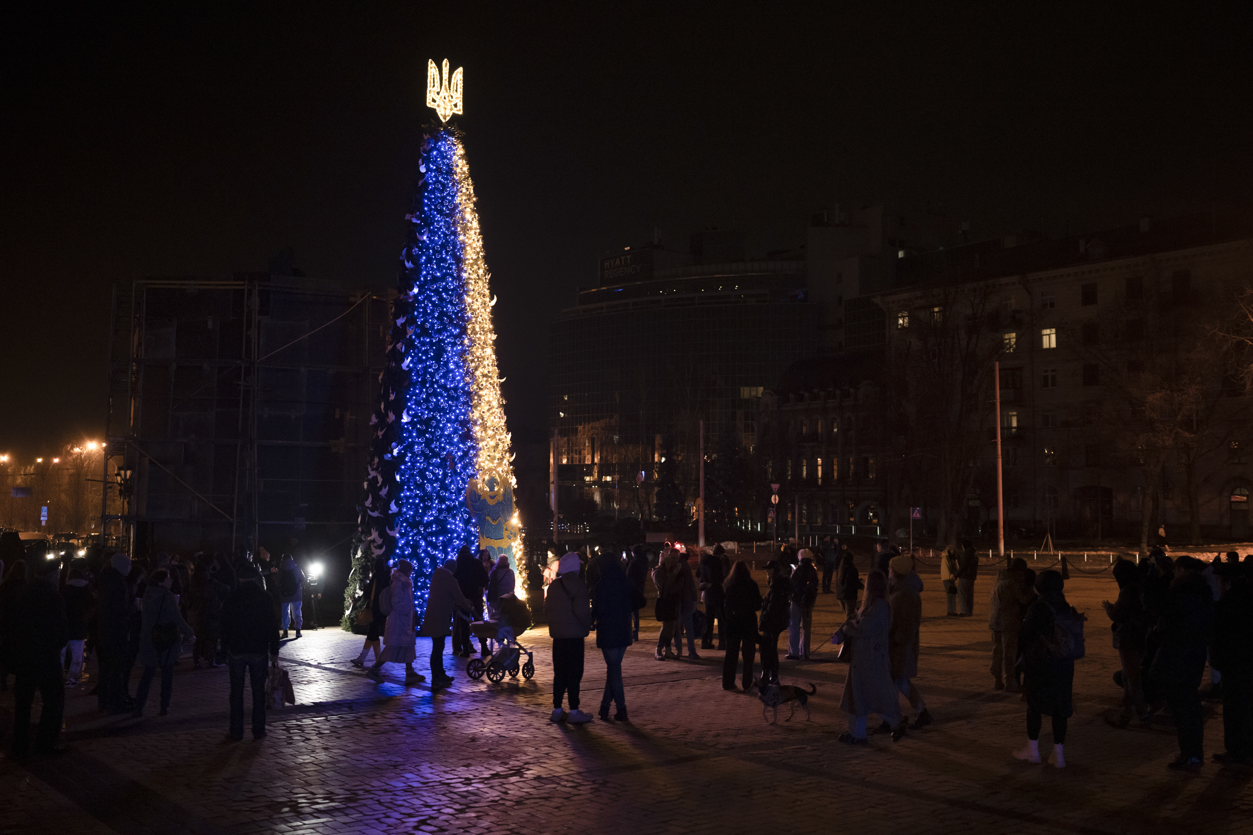 People gather around a Christmas tree decorated with the colors of the Ukrainian national flag at Sophia square in Kyiv, Ukraine, on Friday. 