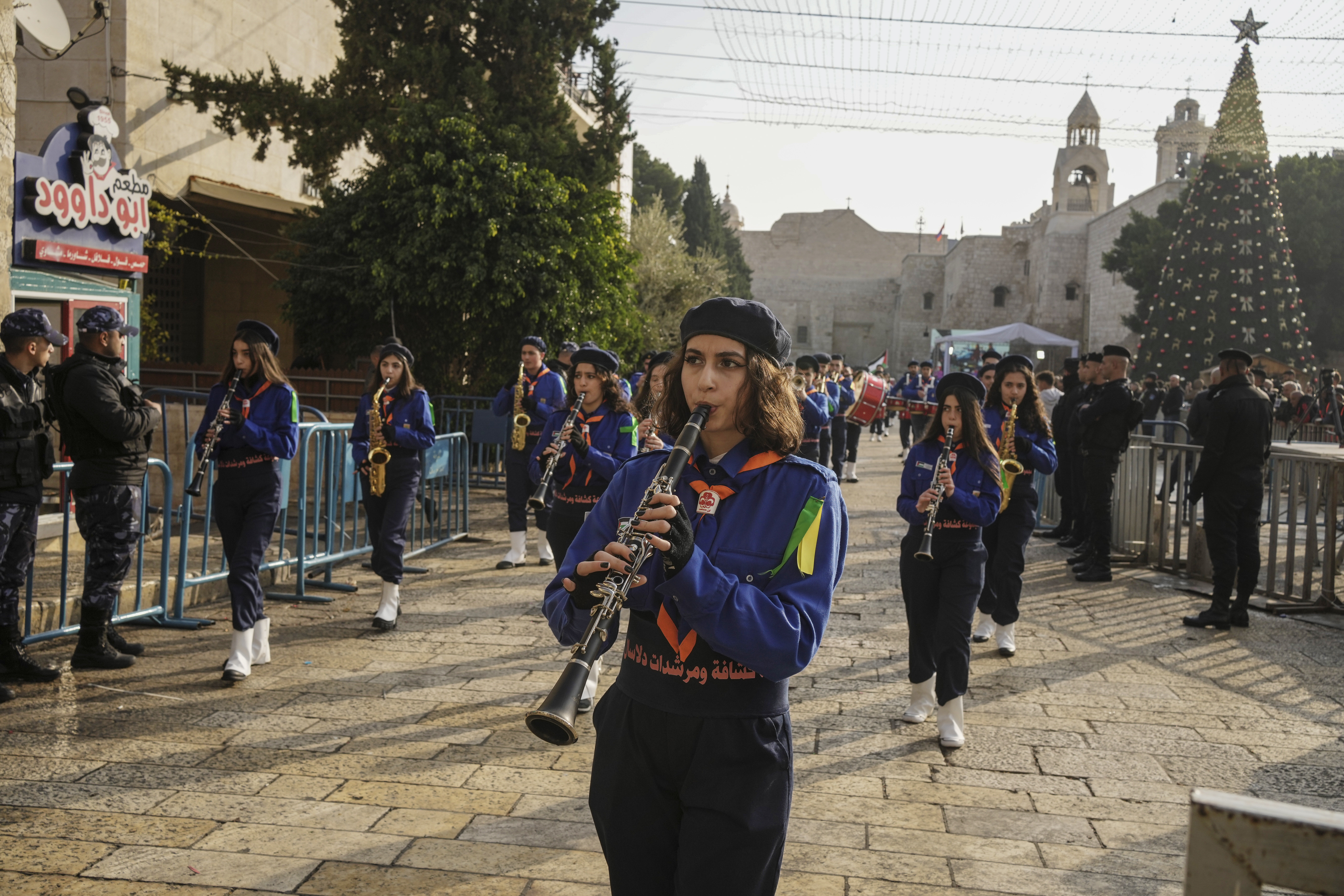 Girls scouts march during a Christmas parade in Manger Square, adjacent to the Church of the Nativity, traditionally believed to be the birthplace of Jesus Christ, in the West Bank town of Bethlehem on Saturday. 