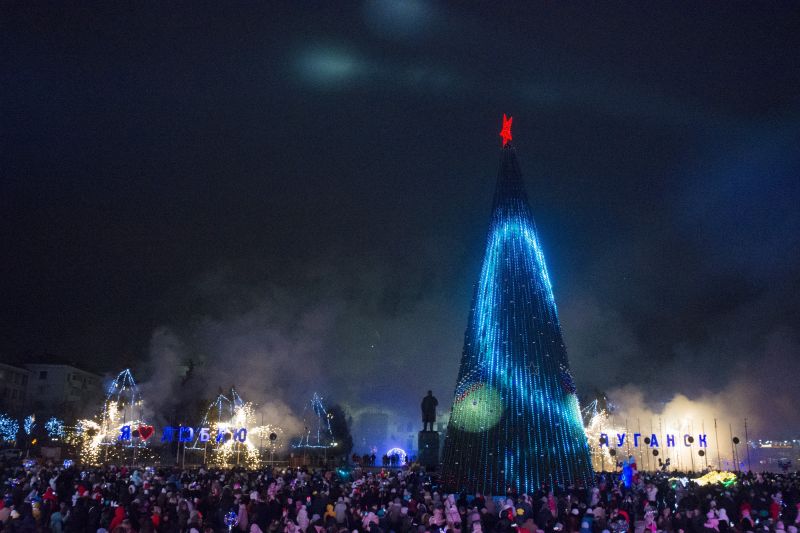 People gather at the Christmas tree decorated for Christmas and the New Year festivities in Luhansk, the capital of Russian-controlled Luhansk region, eastern Ukraine, on Friday.
