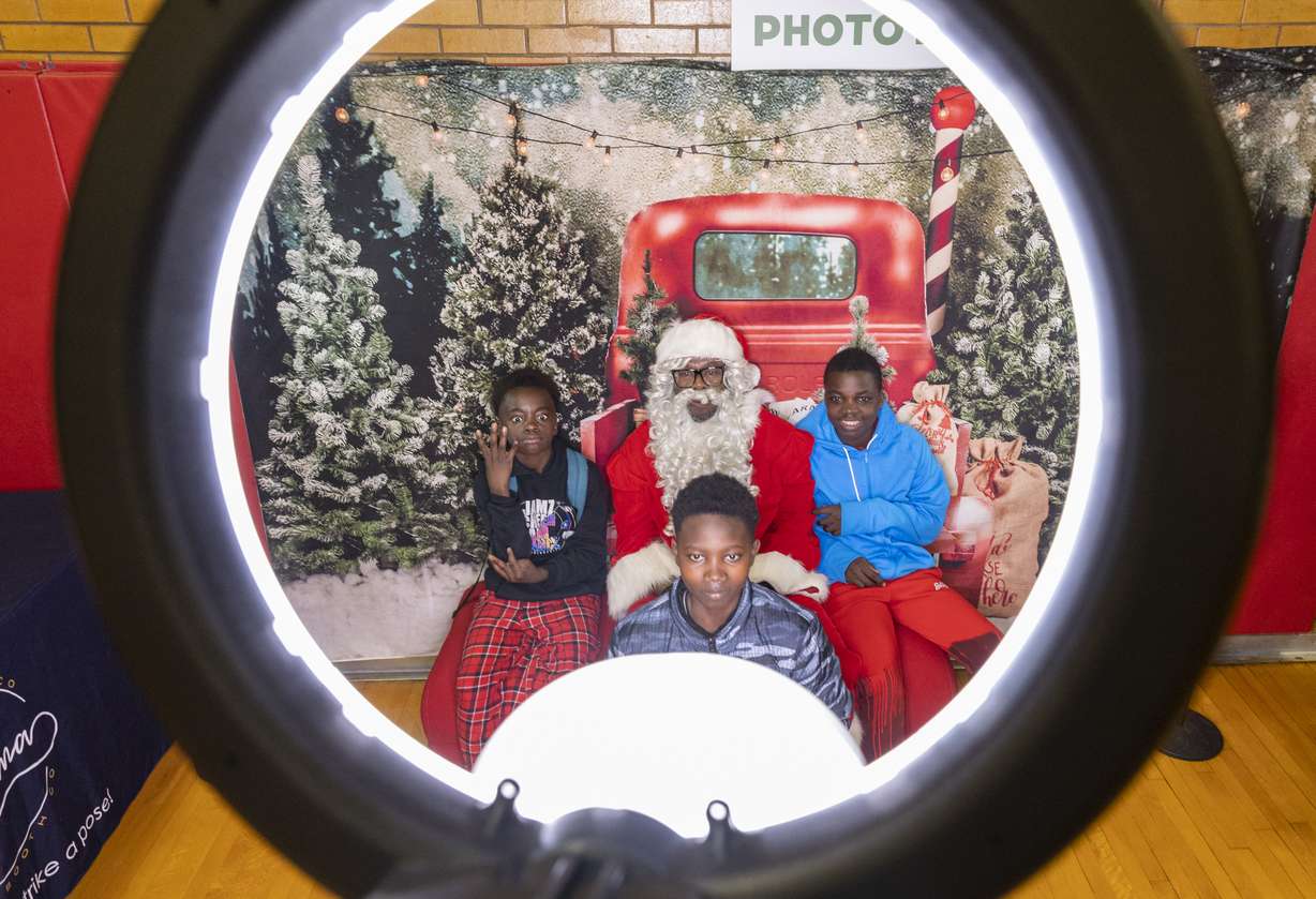 Brothers Faustin Niyonzin, 12, left, Frances, front, and Andre, 15, pose with school principal Milton Collins, who is dressed as Santa, at the Utah Refugee Connection "Celebration of Light" at Lincoln Elementary School in South Salt Lake on Saturday, Dec. 17. It was only a few years ago, in some cases only a few months, that they had never heard "White Christmas," let alone knew what one looked like … and many had no idea who Santa Claus was, either.