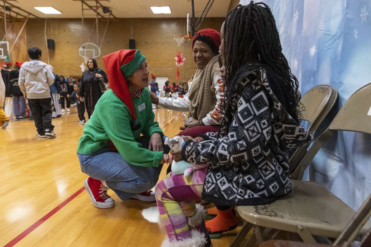 Amy Dott Harmer talks with Rose Ndayishimiye and her family at the Utah Refugee Connection "Celebration of Light" at Lincoln Elementary School in South Salt Lake on Saturday, Dec. 17. It was only a few years ago, in some cases only a few months, that they had never heard "White Christmas," let alone knew what one looked like … and many had no idea who Santa Claus was, either.