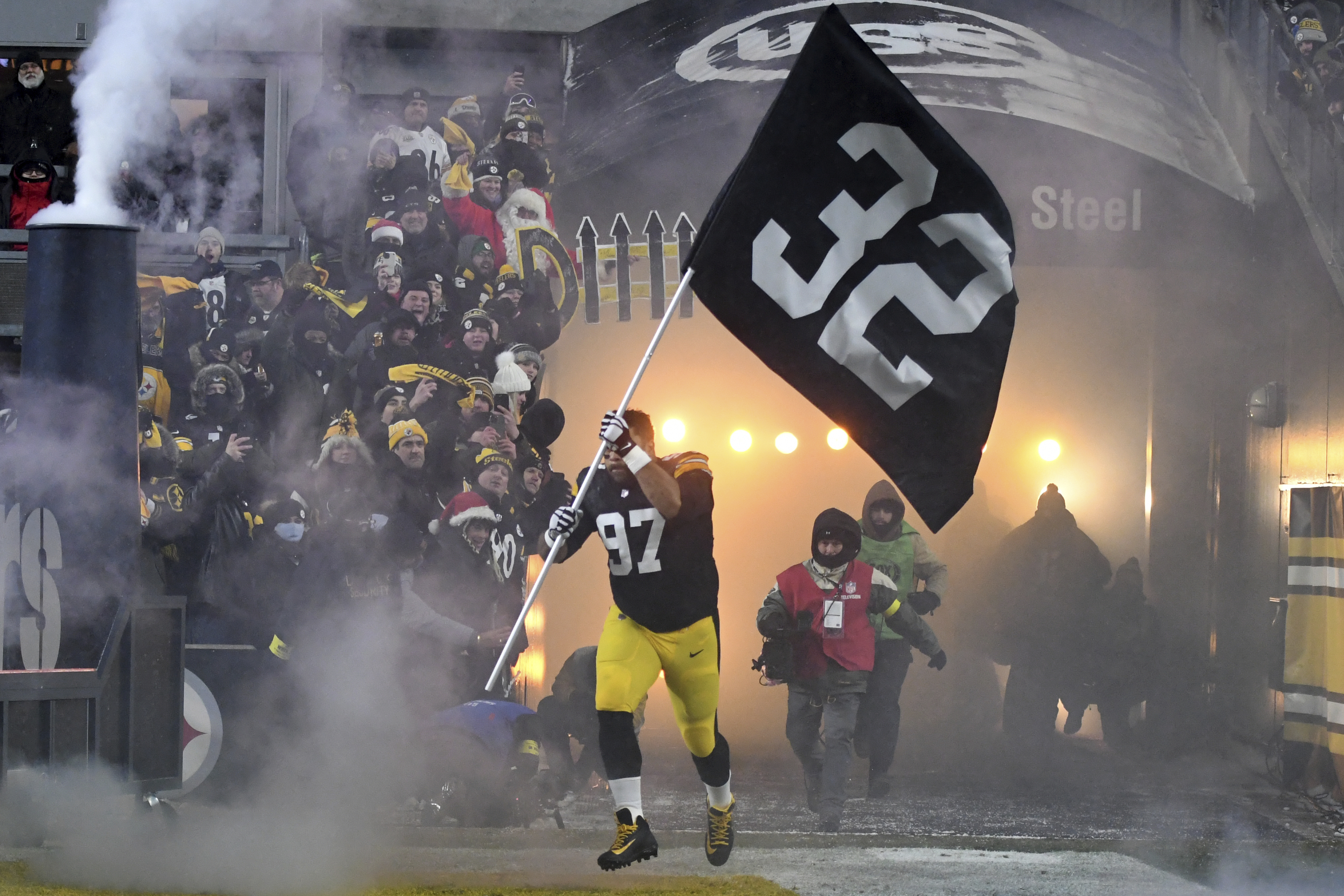 Pittsburgh Steelers defensive tackle Cameron Heyward (97) carries a banner with the uniform number of Pittsburgh Steelers' Franco Harris as he is introduced before an NFL football game against the Las Vegas Raiders in Pittsburgh, Saturday, Dec. 24, 2022. 