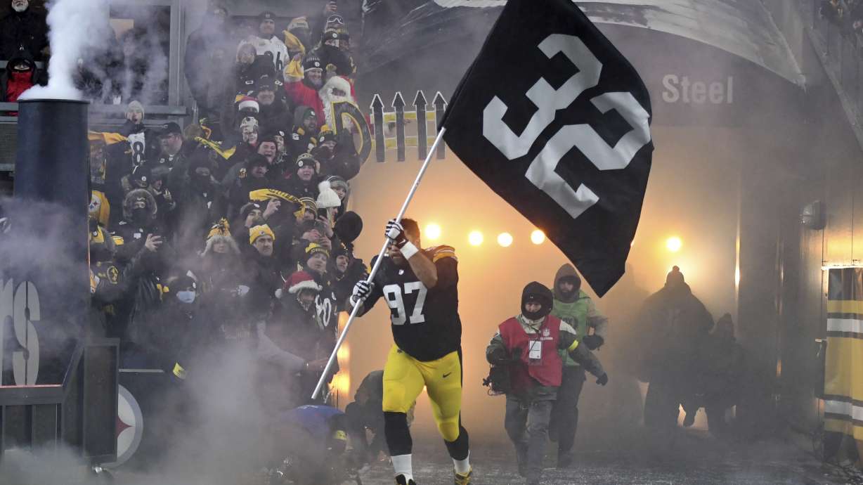 Pittsburgh Steelers defensive tackle Cameron Heyward (97) carries a banner with the uniform number of Pittsburgh Steelers' Franco Harris as he is introduced before an NFL football game against the Las Vegas Raiders in Pittsburgh, Saturday, Dec. 24, 2022.